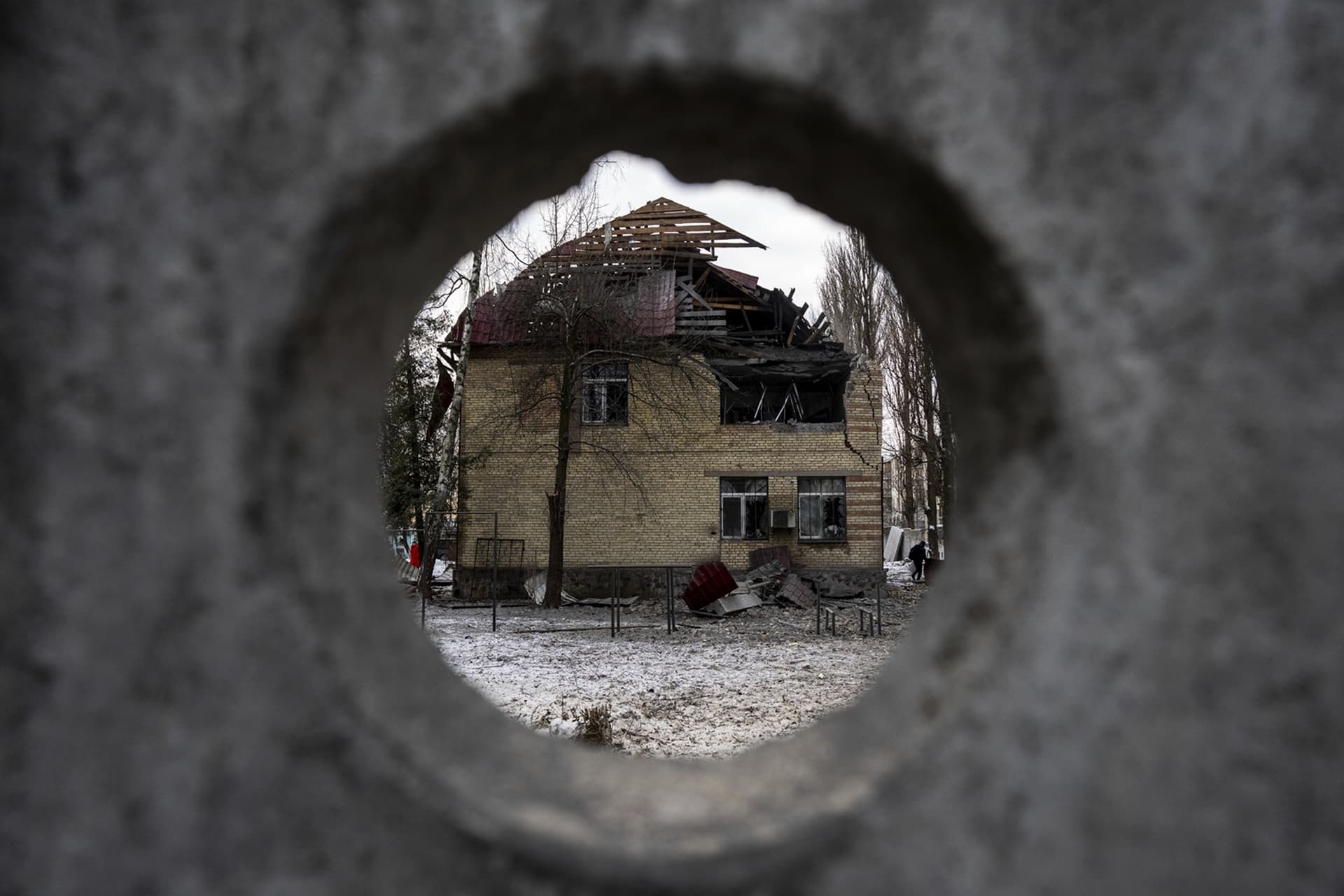 A tax office building that have been heavily damaged by Russian shelling, is seen through the fence, in Kyiv