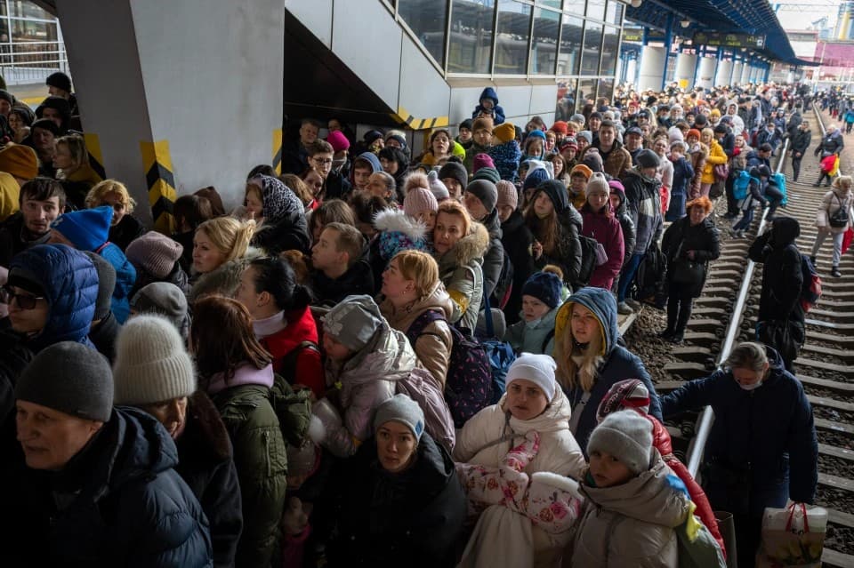 People crowd as they try to get on a train to Lviv at the Kyiv station