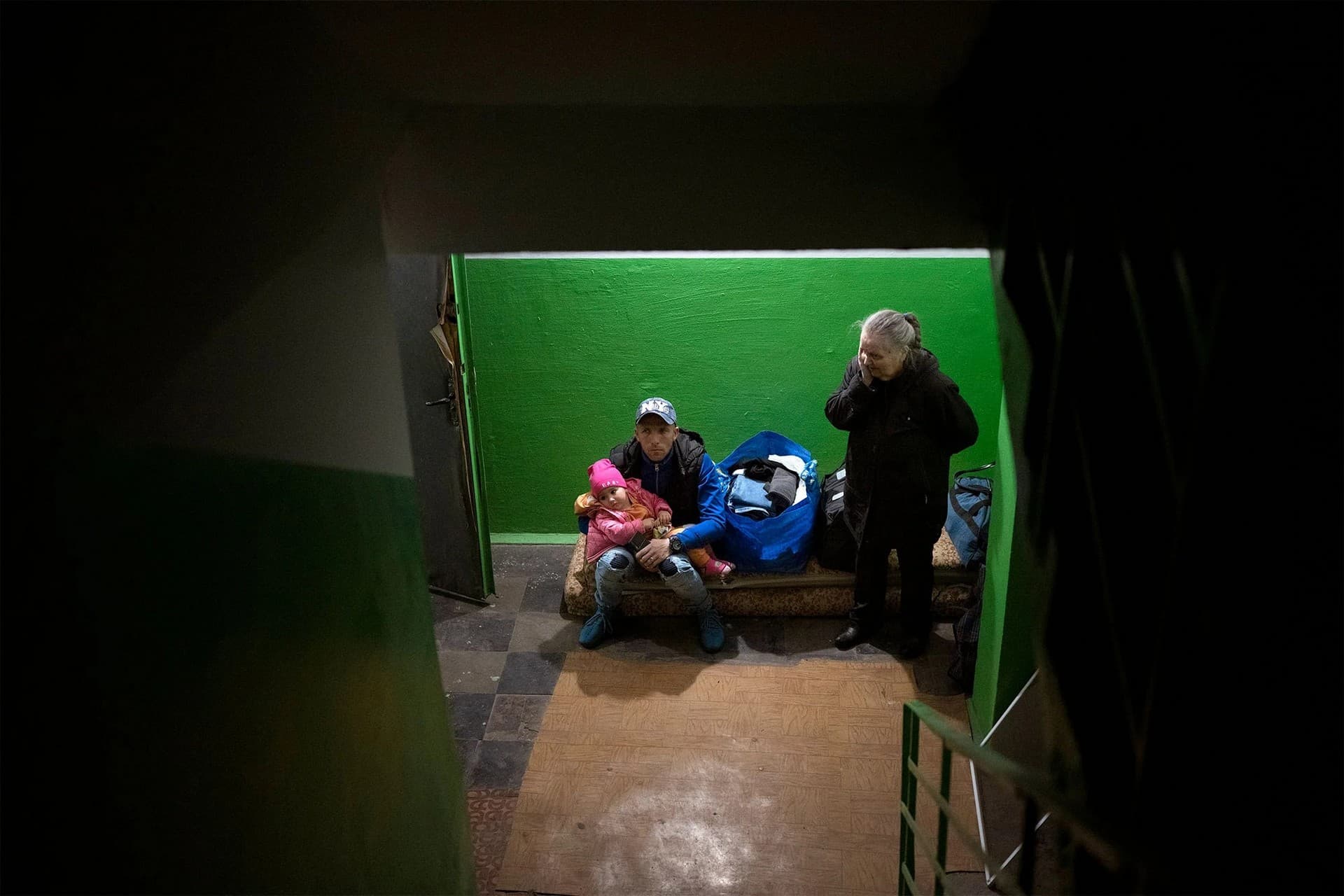 People take shelter in the basement of a residential building in Kyiv