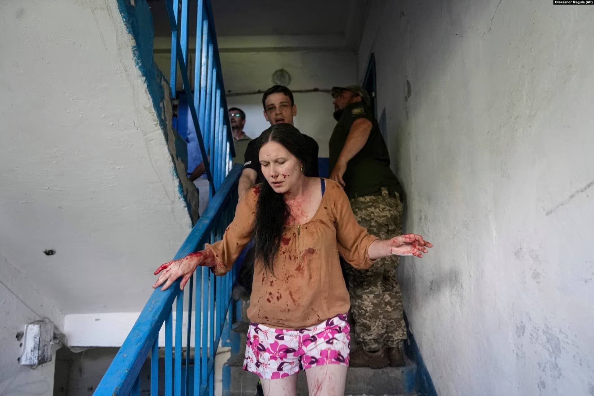 An injured woman runs down a staircase