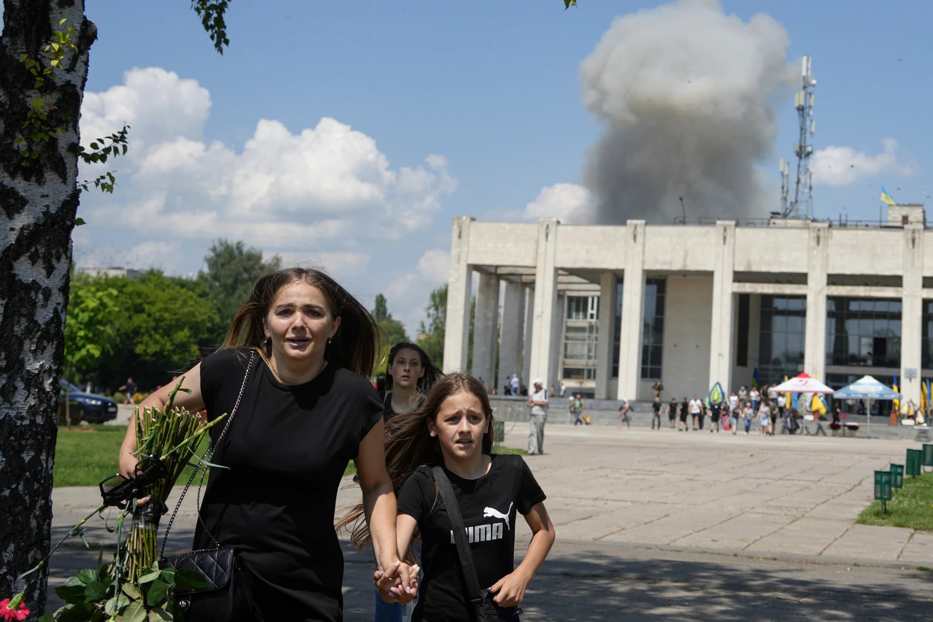 A family runs from an explosion in Pervomaiskyi, Ukraine. Photo: AP