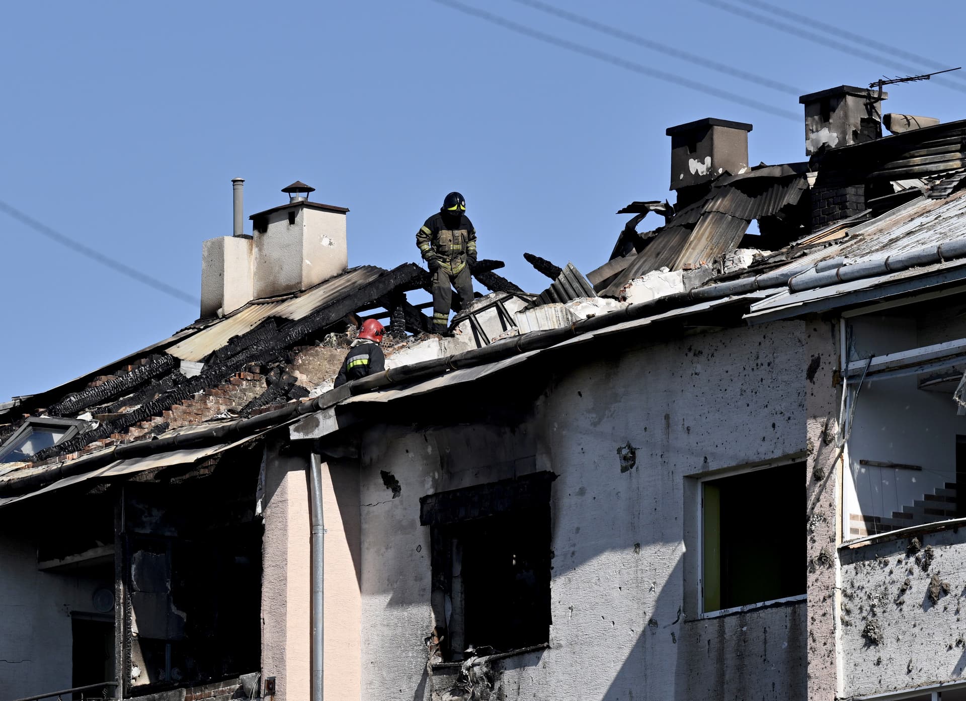 A rescuer examines a roof of a damaged residential building after missile strike on the city of Lviv
