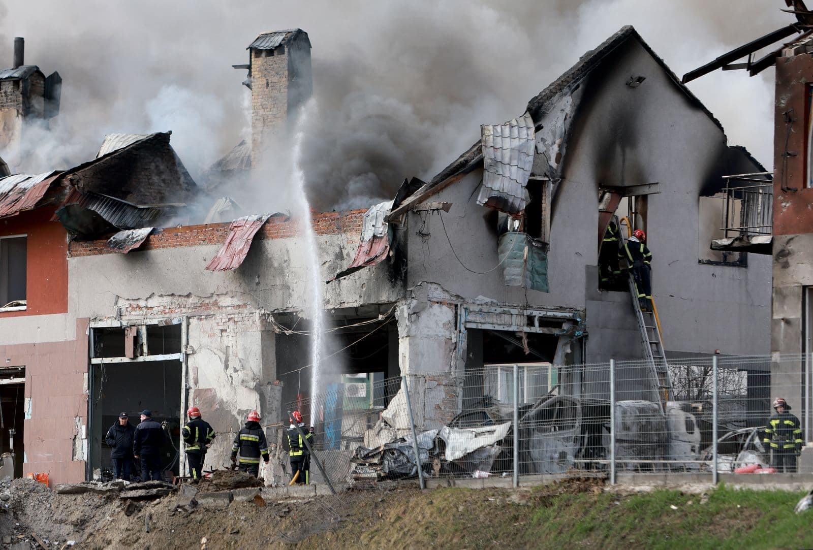 Firefighters work in Lviv after a civilian building was hit by a Russian missile