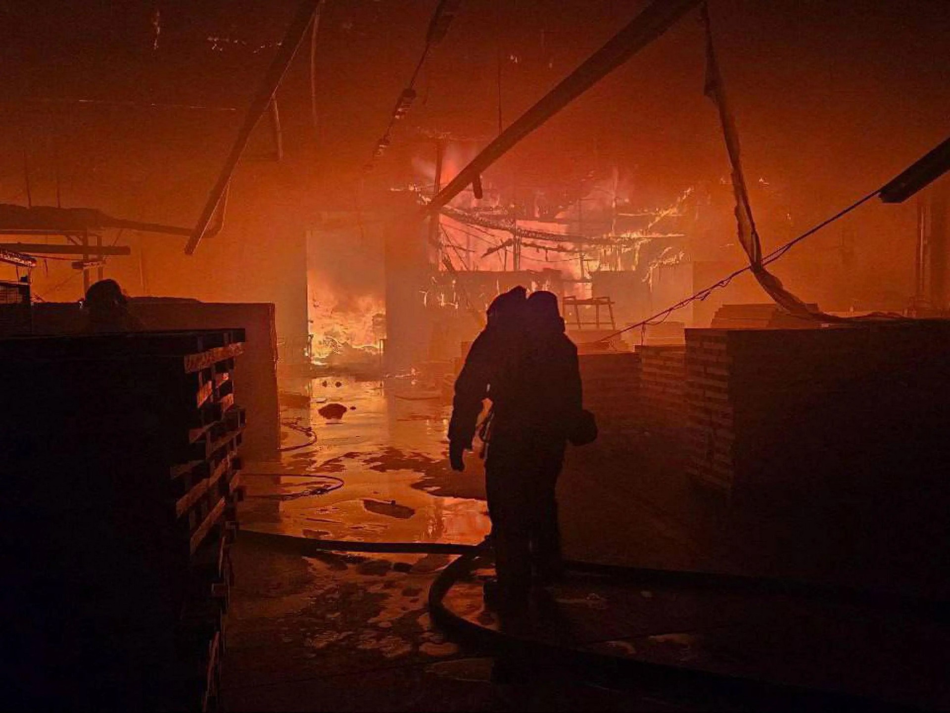 emergency services personnel work to extinguish a fire following a Russian attack in Lviv