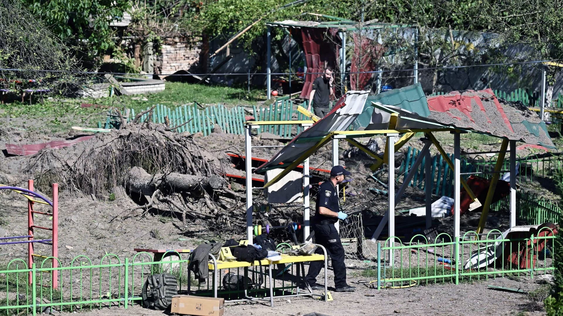 A police expert examines the damage to a kindergarten hit by a Russian missile strike in the city of Lviv