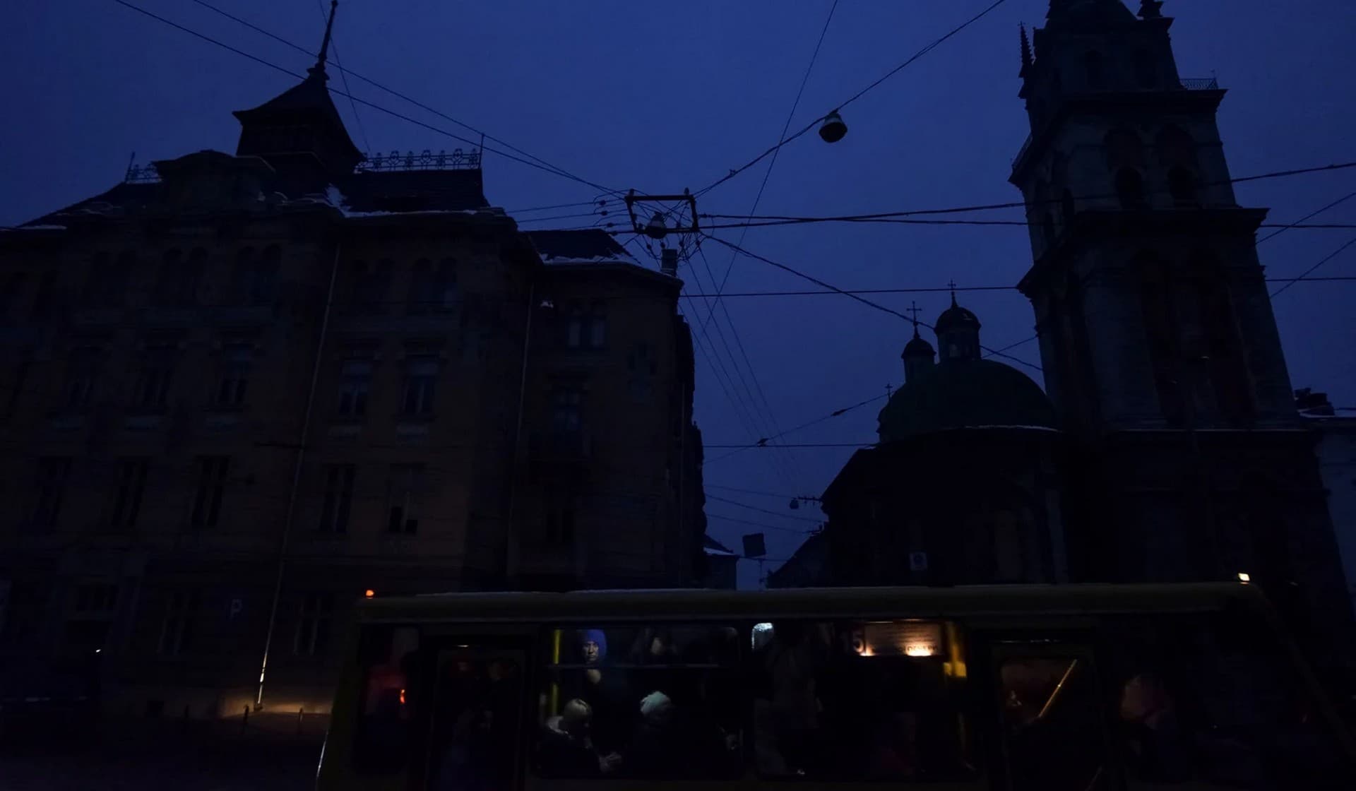 People ride on a bus in the city center without electricity in Lviv