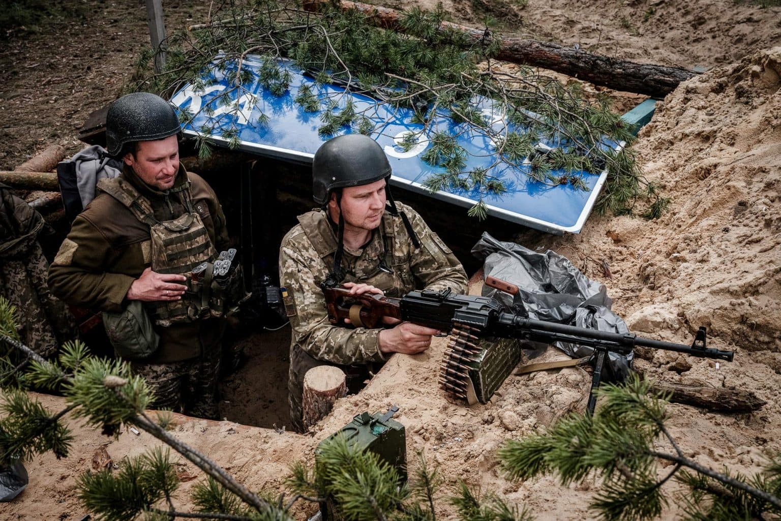 Ukrainian servicemen stand in a trench near the town of Lyman