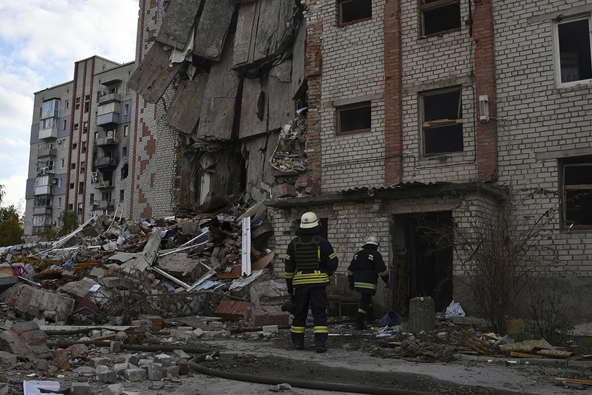 Firefighters work at the scene of a damaged residential building after Russian shelling in the liberated Lyman