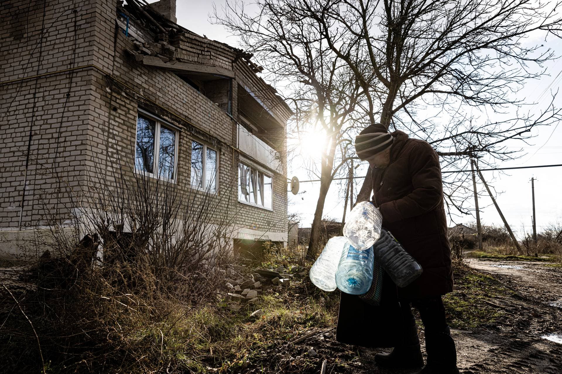 Nadezhda Vasilievna fetches water after the war in Ukraine cut off water service in the village of Lazove