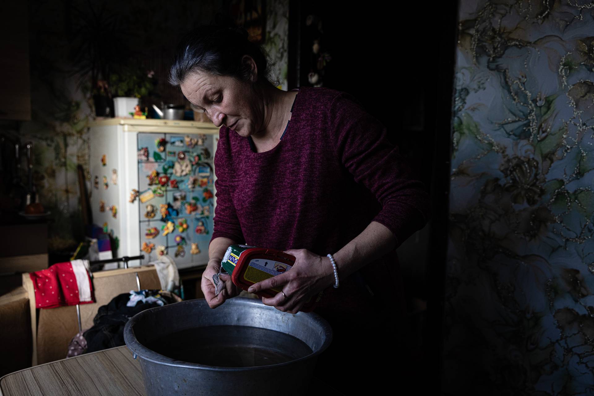 With no electricity, heating or running water, Tatiana collects rainwater to wash the clothes of her and her son