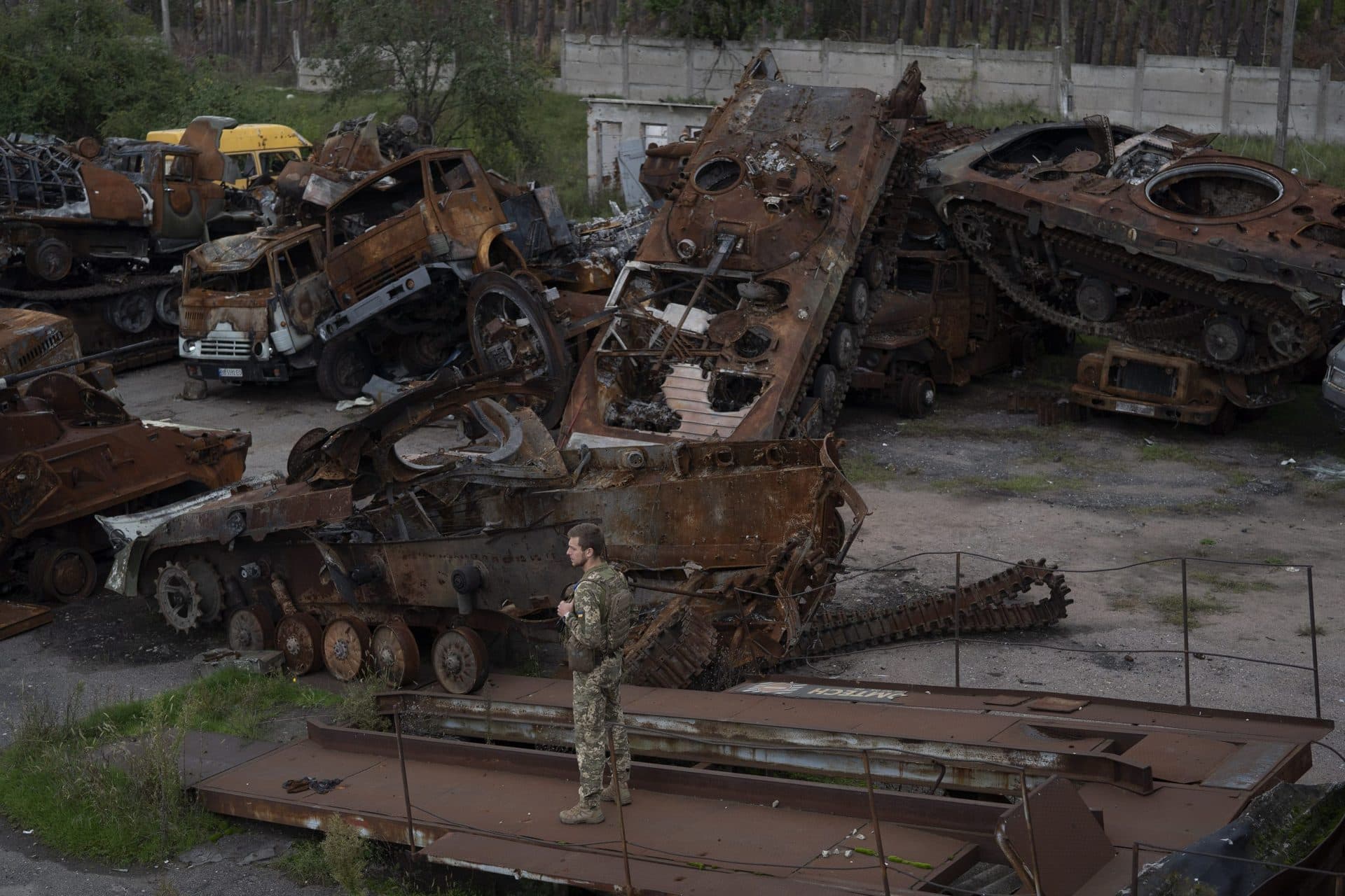 A Ukrainian serviceman stands next to destroyed Russian equipment placed in an area at the recaptured town of Lyman