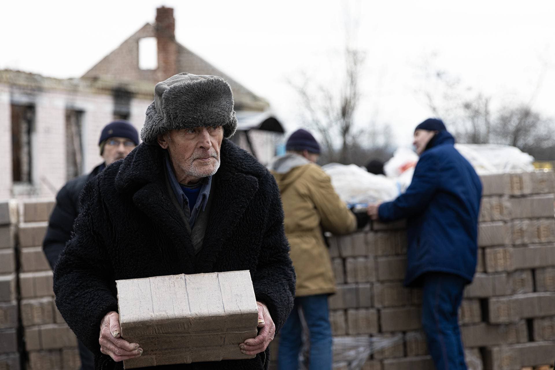 A Dibrova resident collects dry fuel bricks brought by the Red Cross