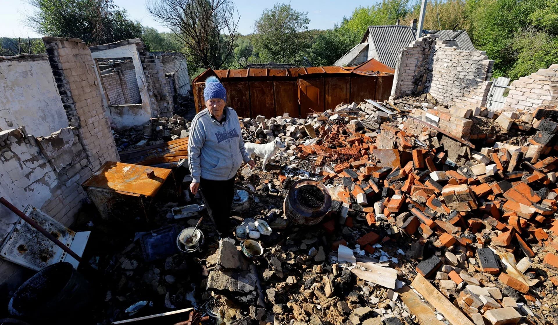 Local resident stands amidst debris of her destroyed house near Lysychansk
