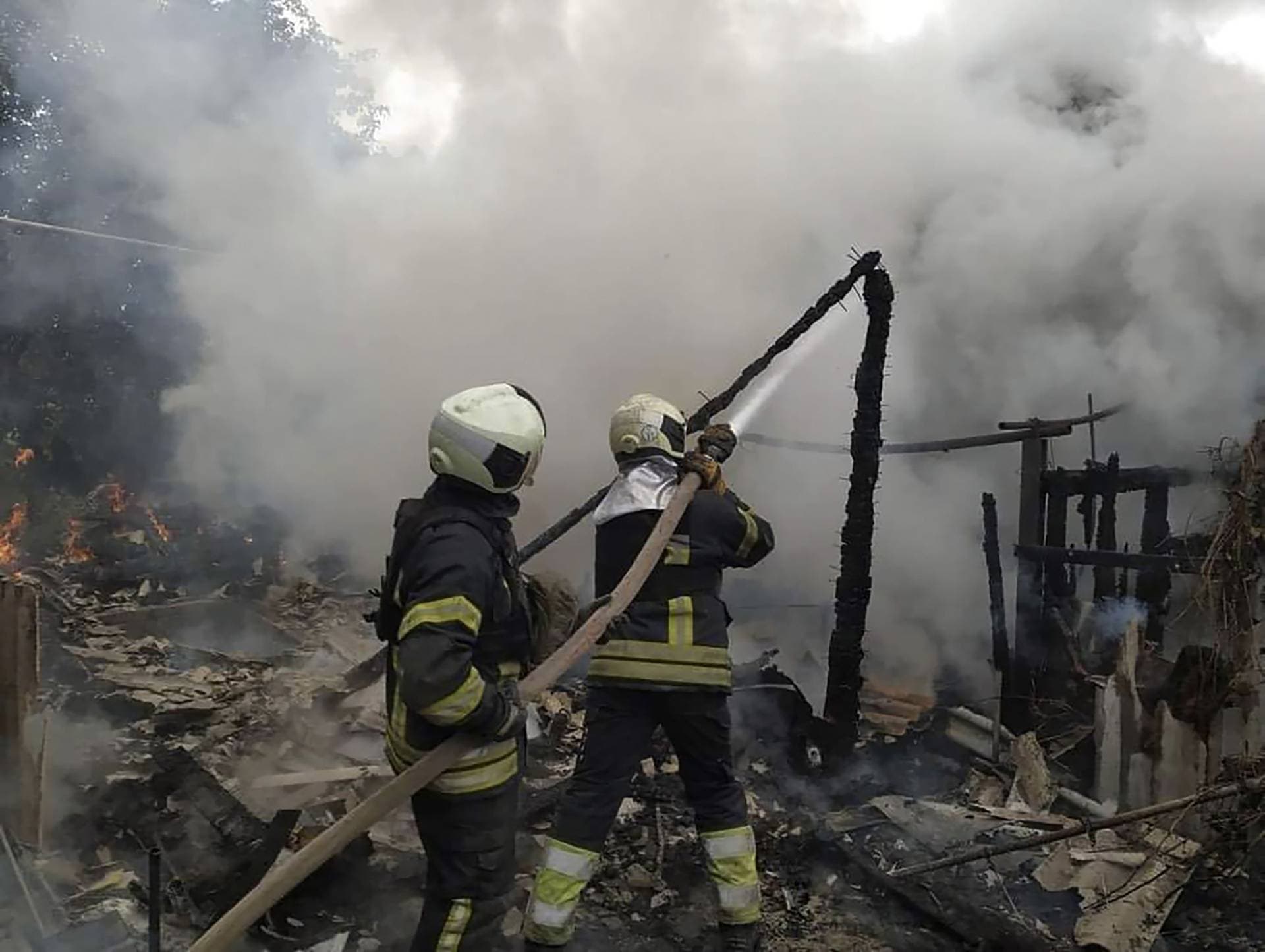 Ukrainian firefighters work to extinguish a fire at damaged residential building in Lysychansk