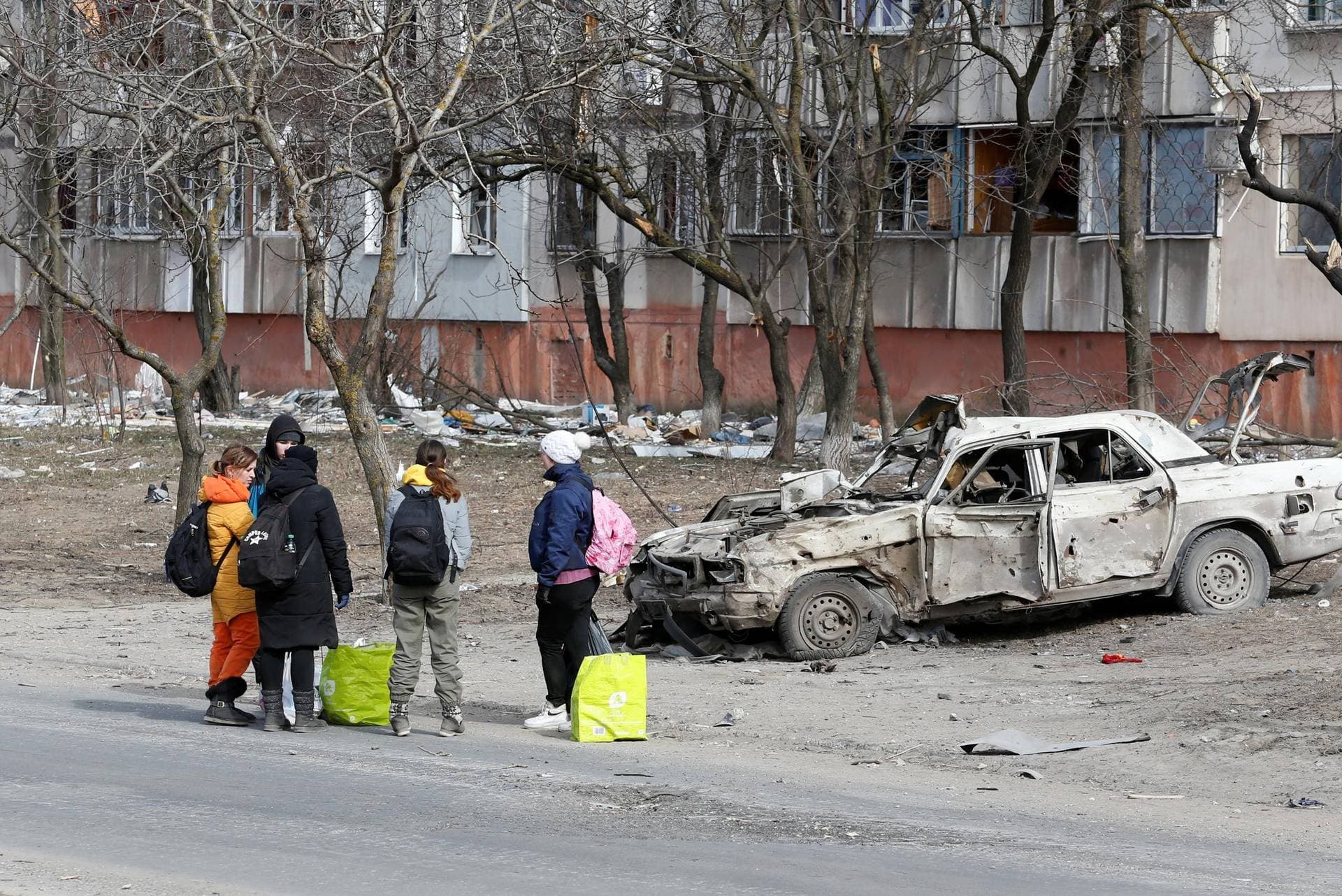 Refugees gather in a street as they leave the besieged port city of Mariupol