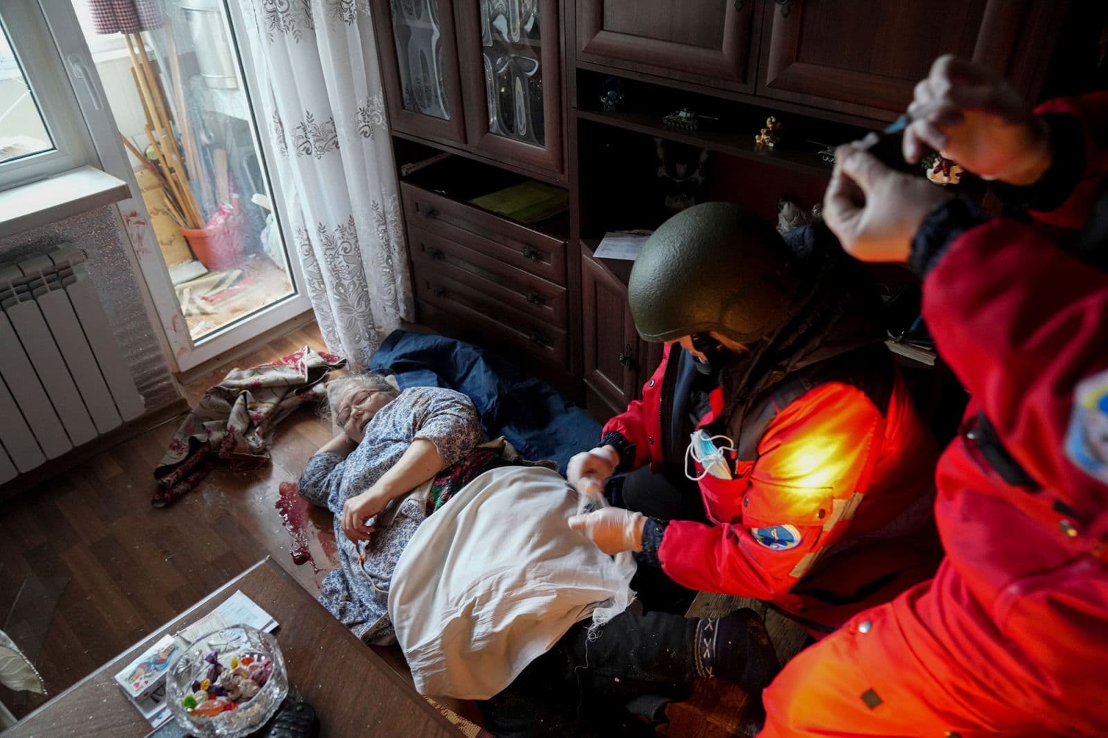 Paramedics treat an elderly woman wounded by shelling before transferring her to a hospital in Mariupol