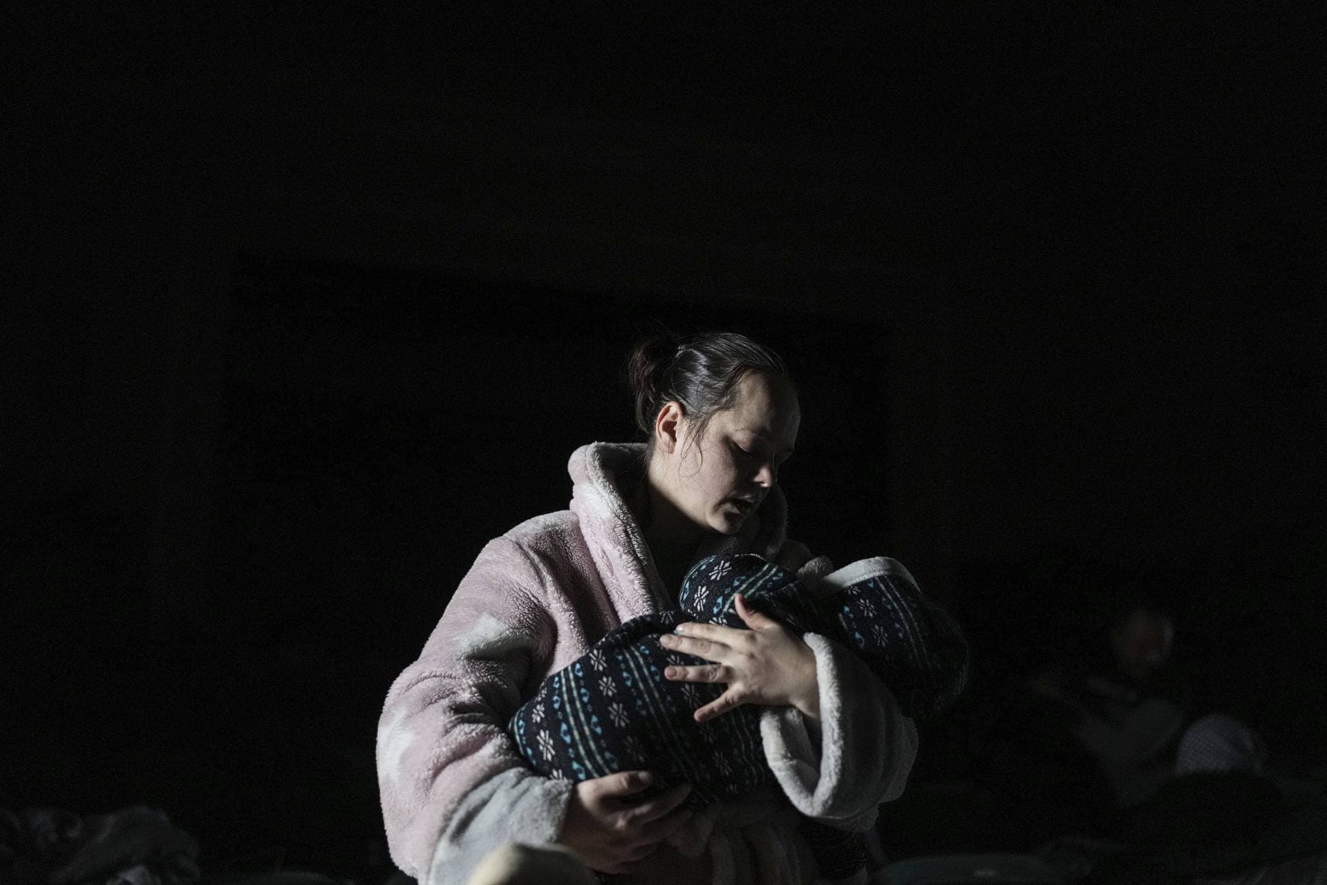 A woman with a child in her arms in a bomb shelter in Mariupol
