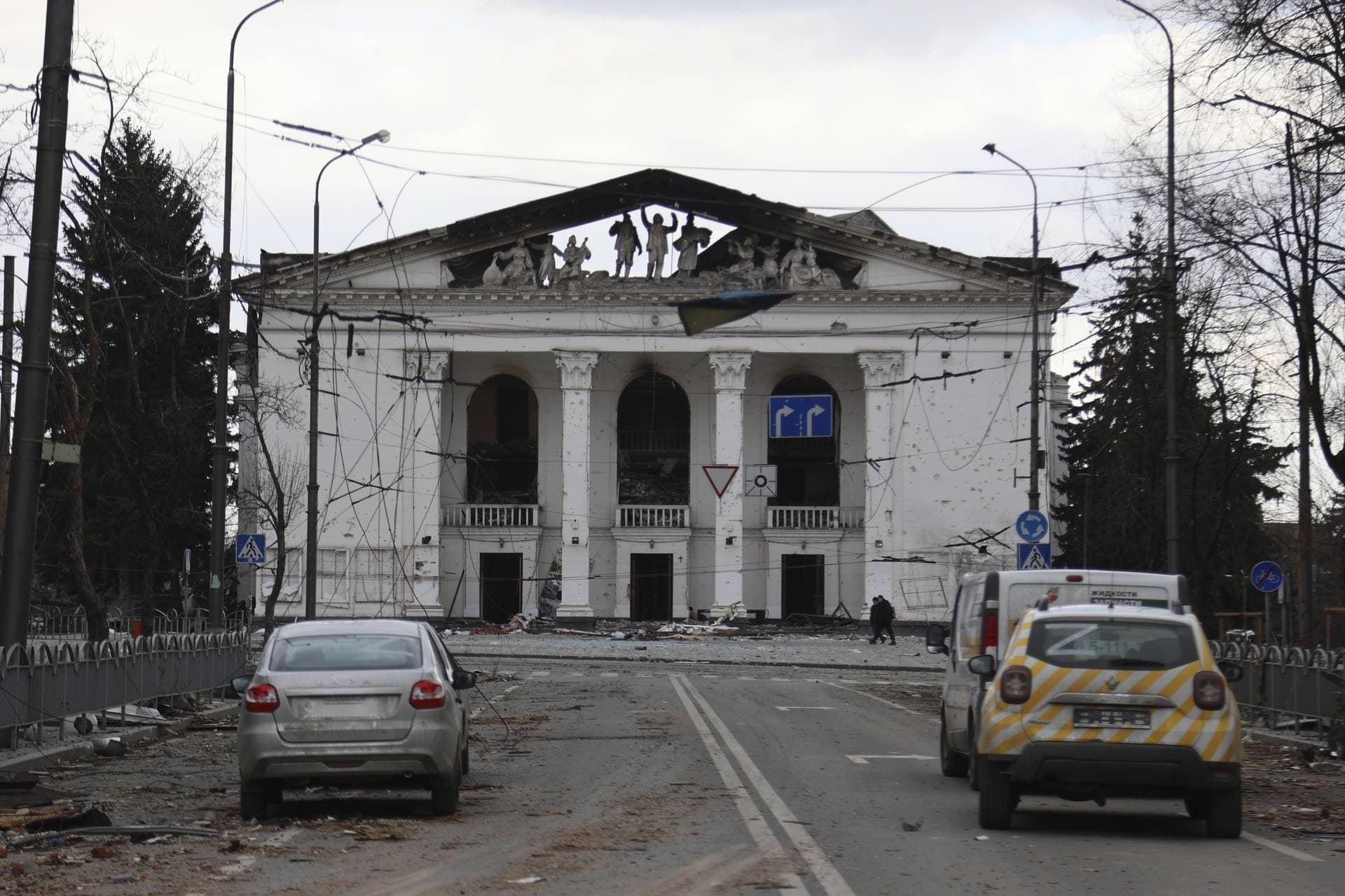 People walk past the Donetsk Academic Regional Drama Theatre in Mariupol
