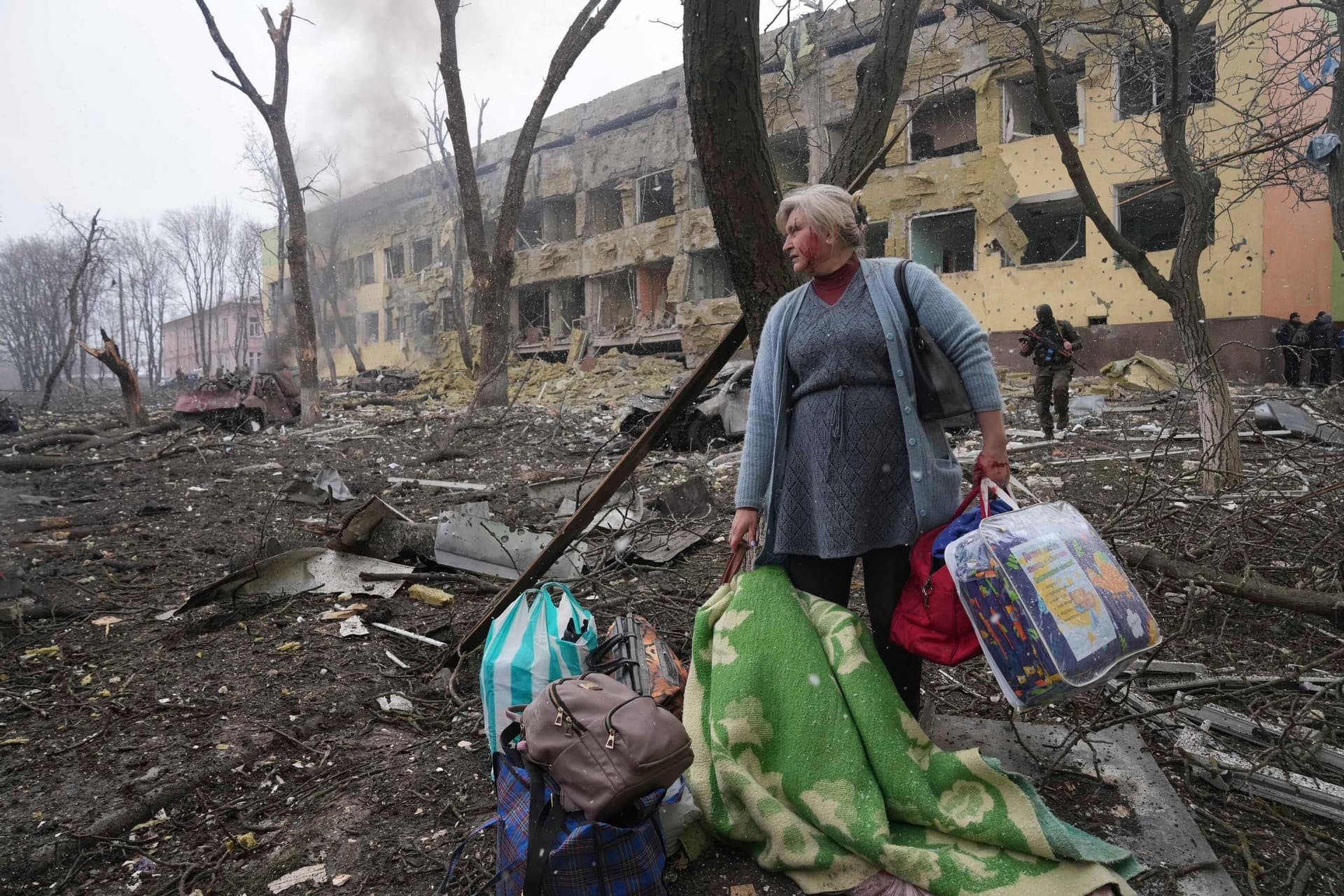 A woman walks outside a maternity hospital that was damaged by shelling in Mariupol