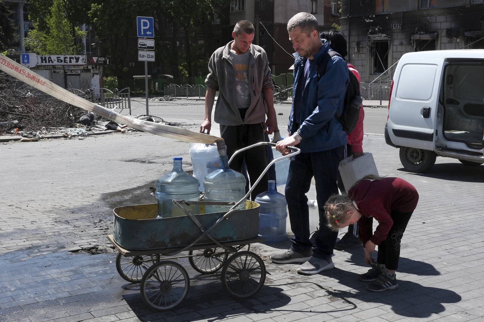 Local residents fil bottles with drinking water in Mariupol