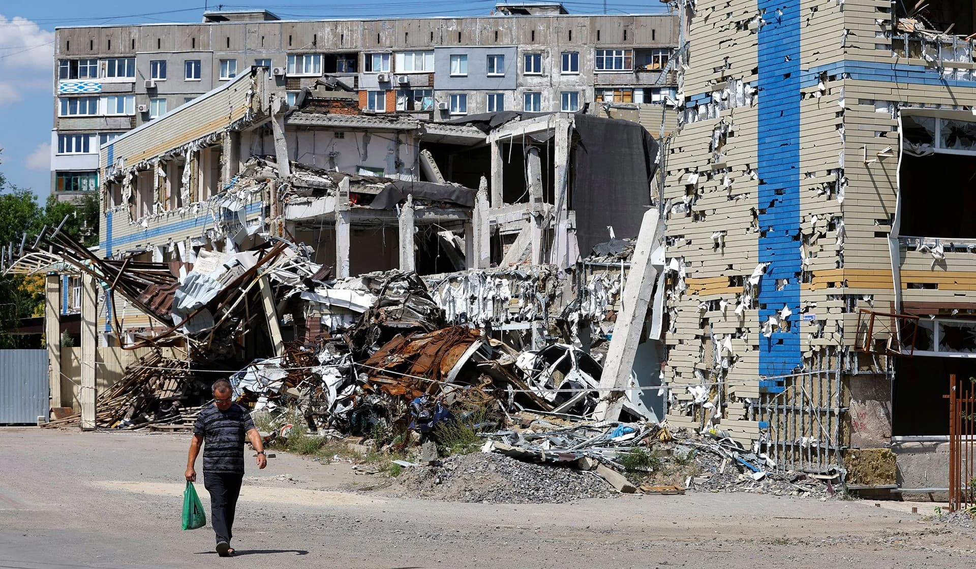 A man walks past a destroyed building in Mariupol