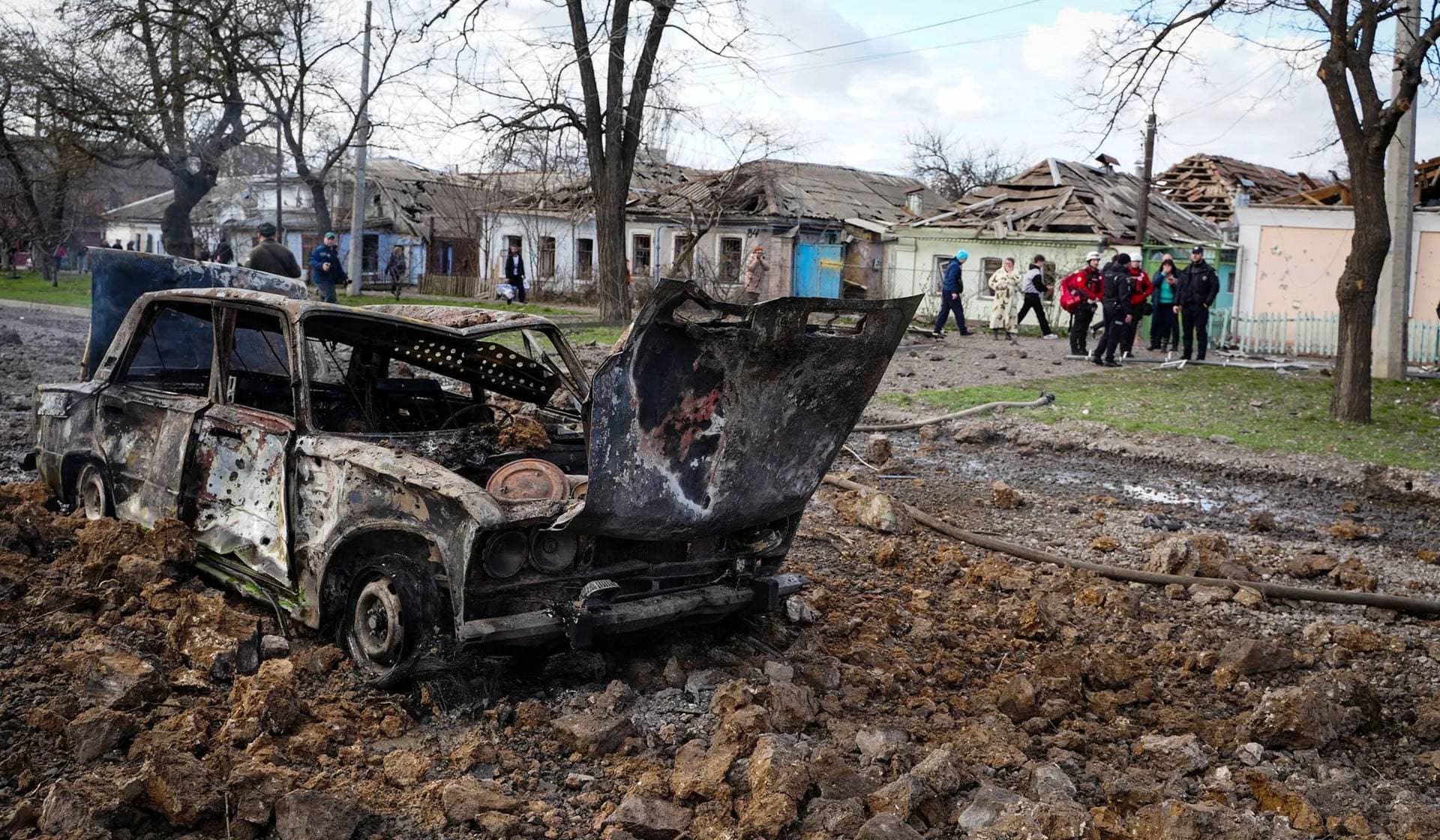 A destroyed car and damaged residential buildings at the site of a Russian missile strike in Mykolaiv