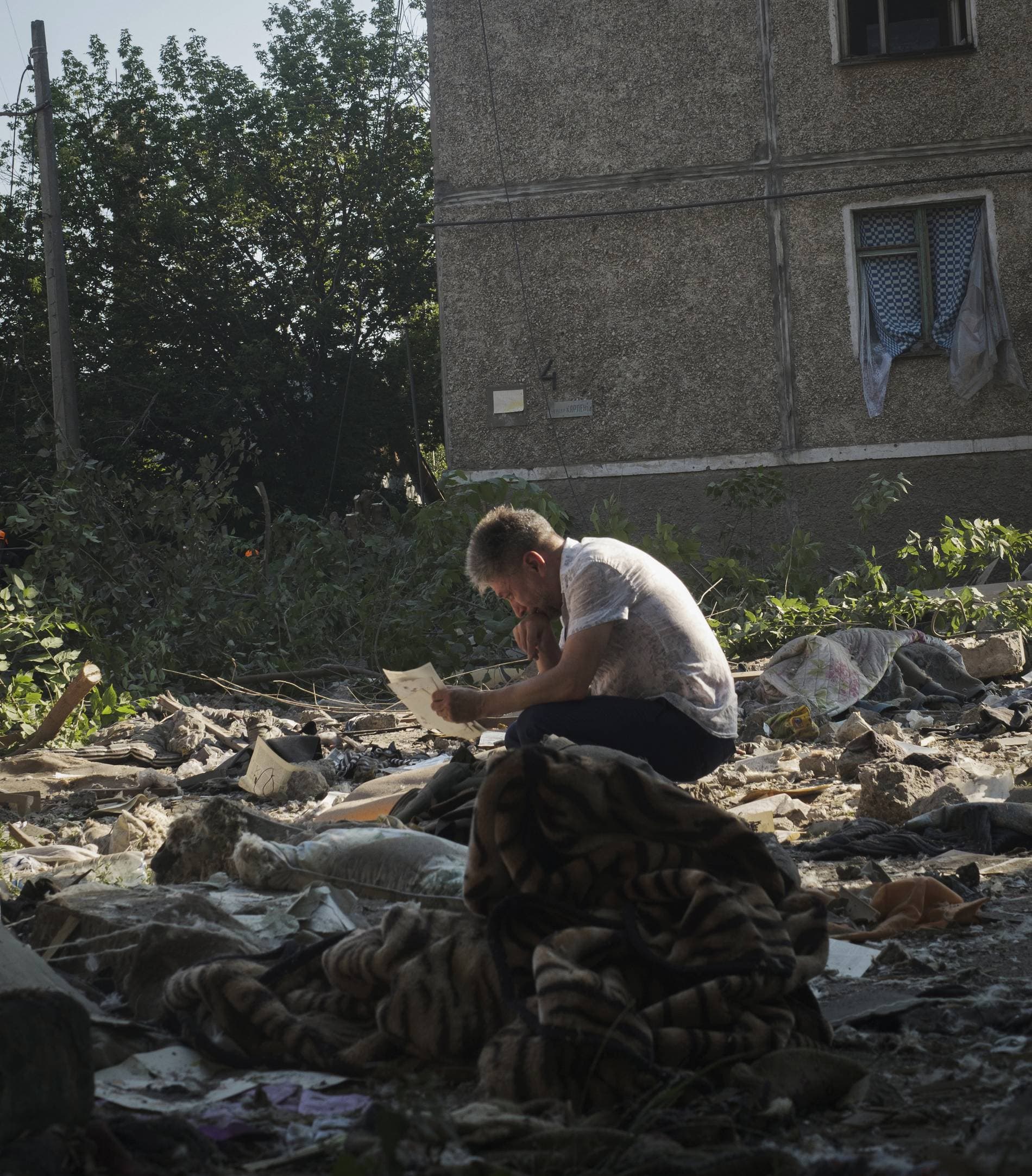 A local resident collects photos of his family left under the rubble after Russian shelling in Mykolaiv