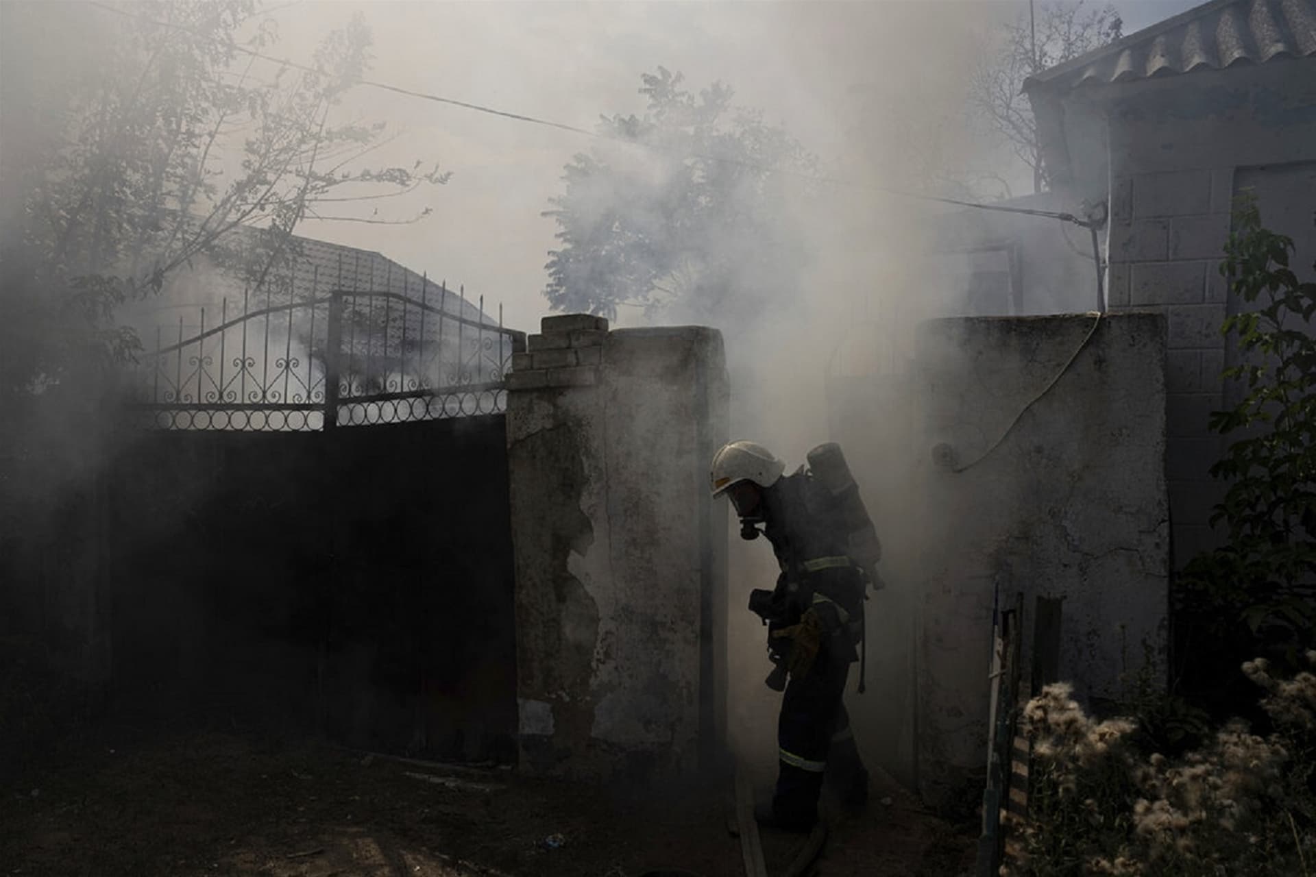 A rescue worker puts out the fire at the house destroyed by a Russian attack in Mykolaiv