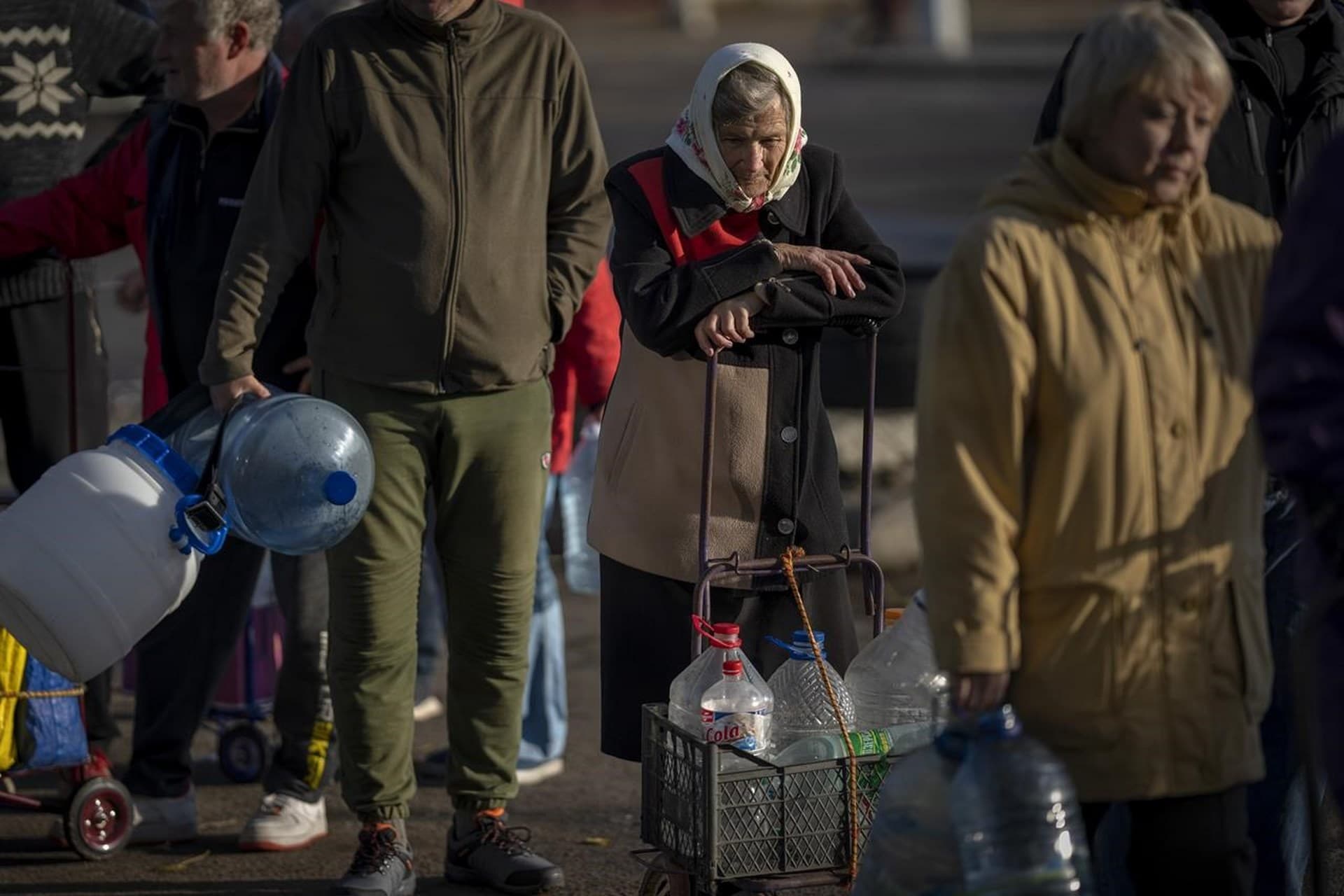 Olha Fedorivna, 83, waits to refill her plastic bottles with drinking water from a tank in the center of Mykolaiv