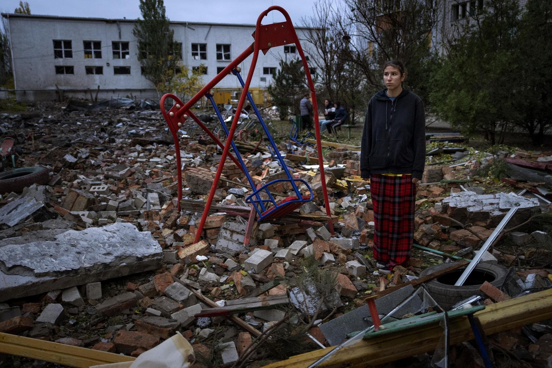 Taisiia Kovaliova stands amongst the rubble of a playground in front of her house hit by a Russian missile in Mykolaiv