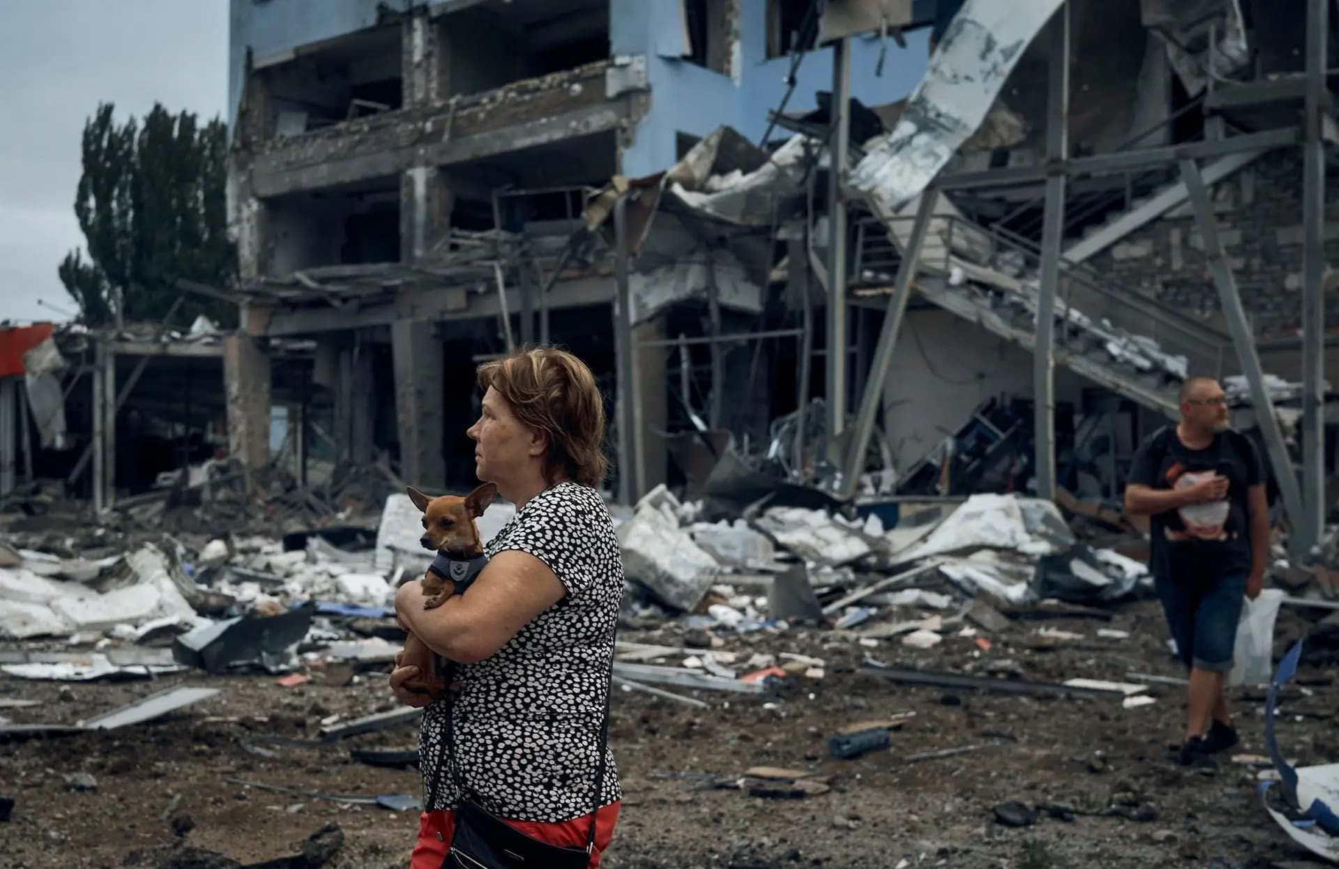 A woman holds a dog in the aftermath of the Russian shelling in Mykolaiv