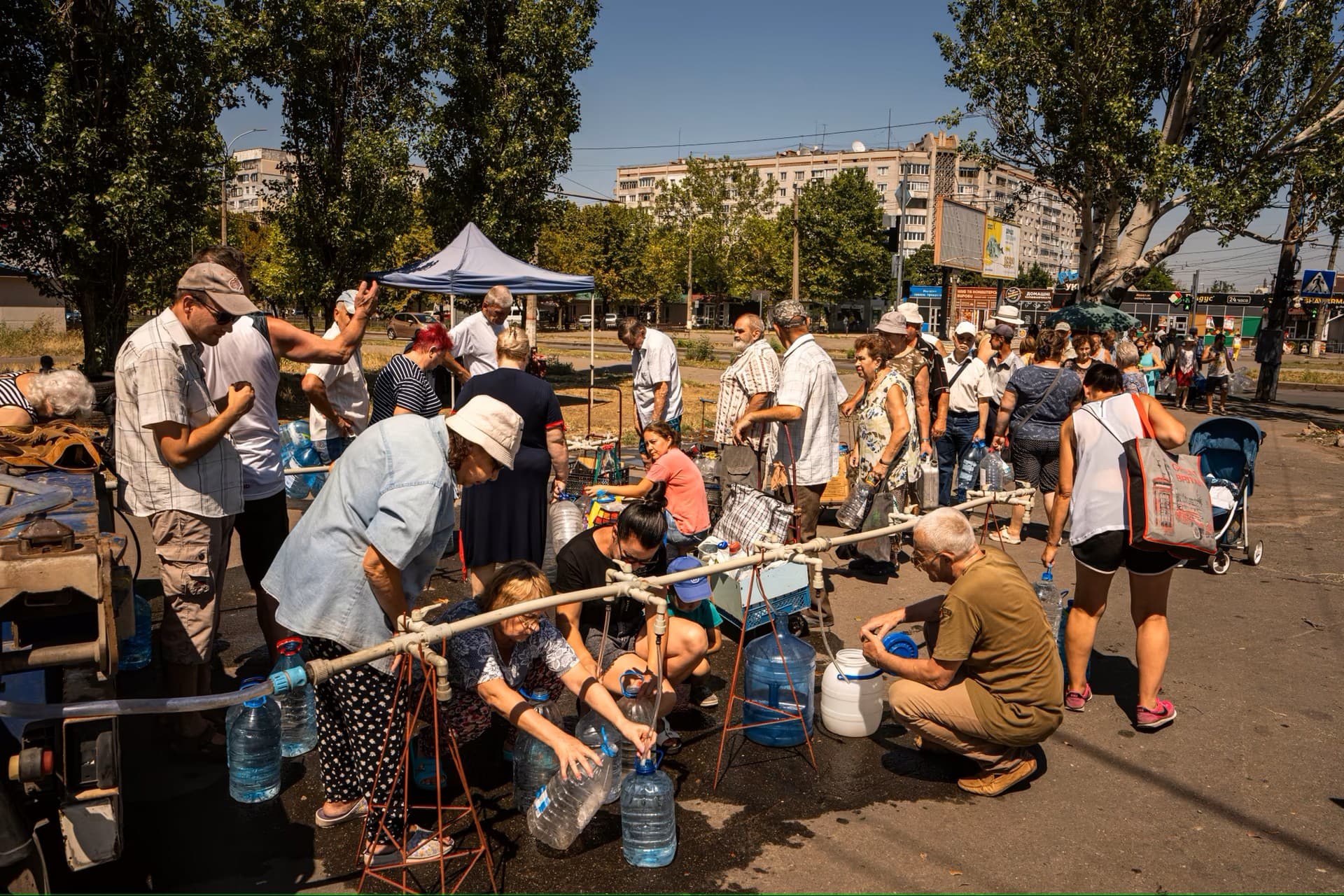residents in  Mykolaiv collecting water being provided by volunteers