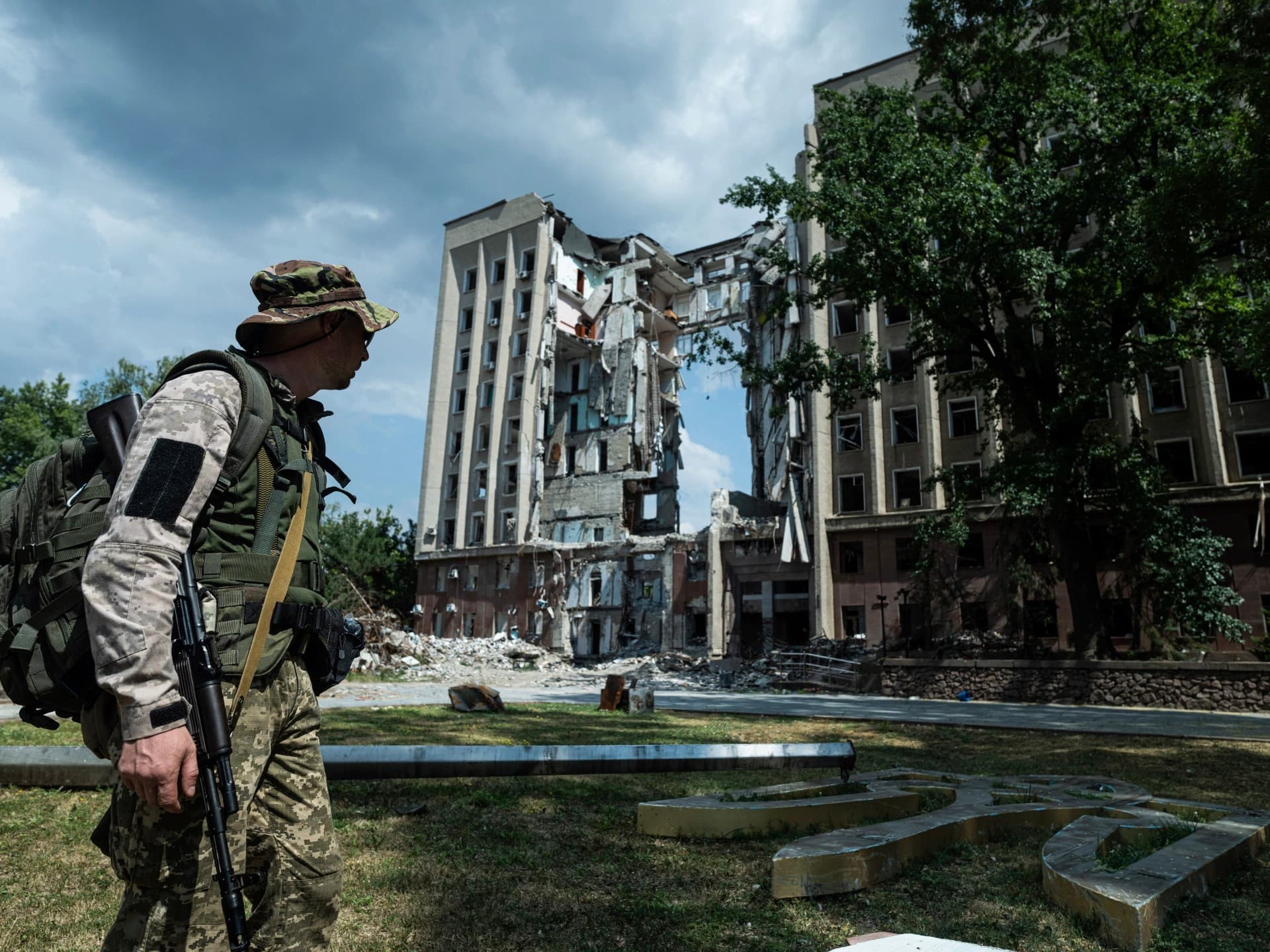 A Ukrainian serviceman stands in front of the destroyed headquarters of the Mykolaiv Regional Military Administration building in Mykolaiv
