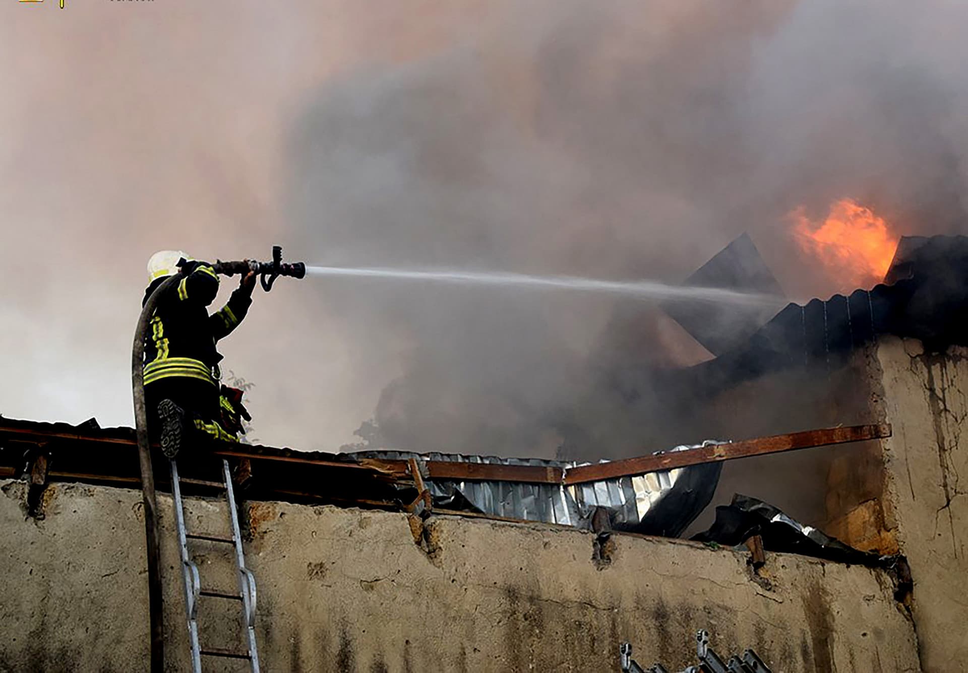 A firefighter puts out a fire on a building after shelling in Mykolaiv, Ukraine