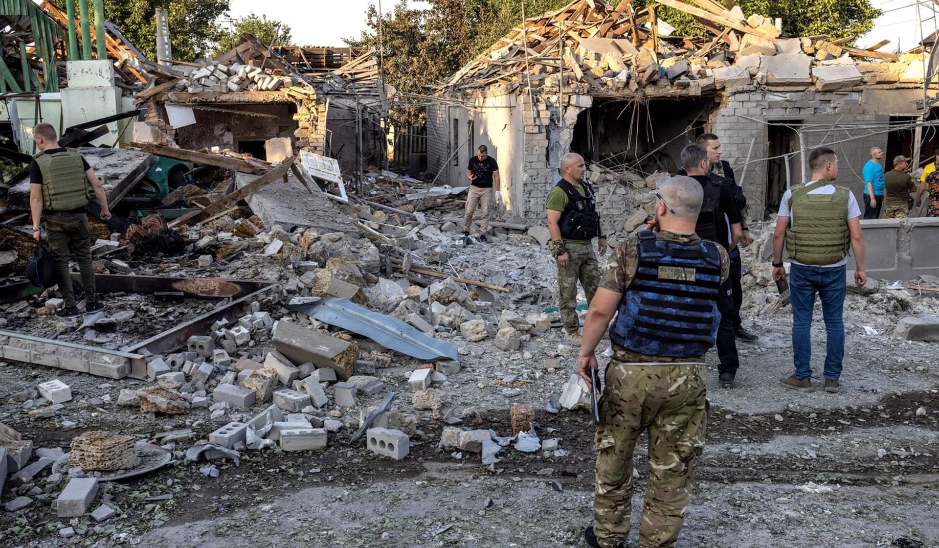 Police and military officers inspect destroyed houses by a strike in Mykolaiv
