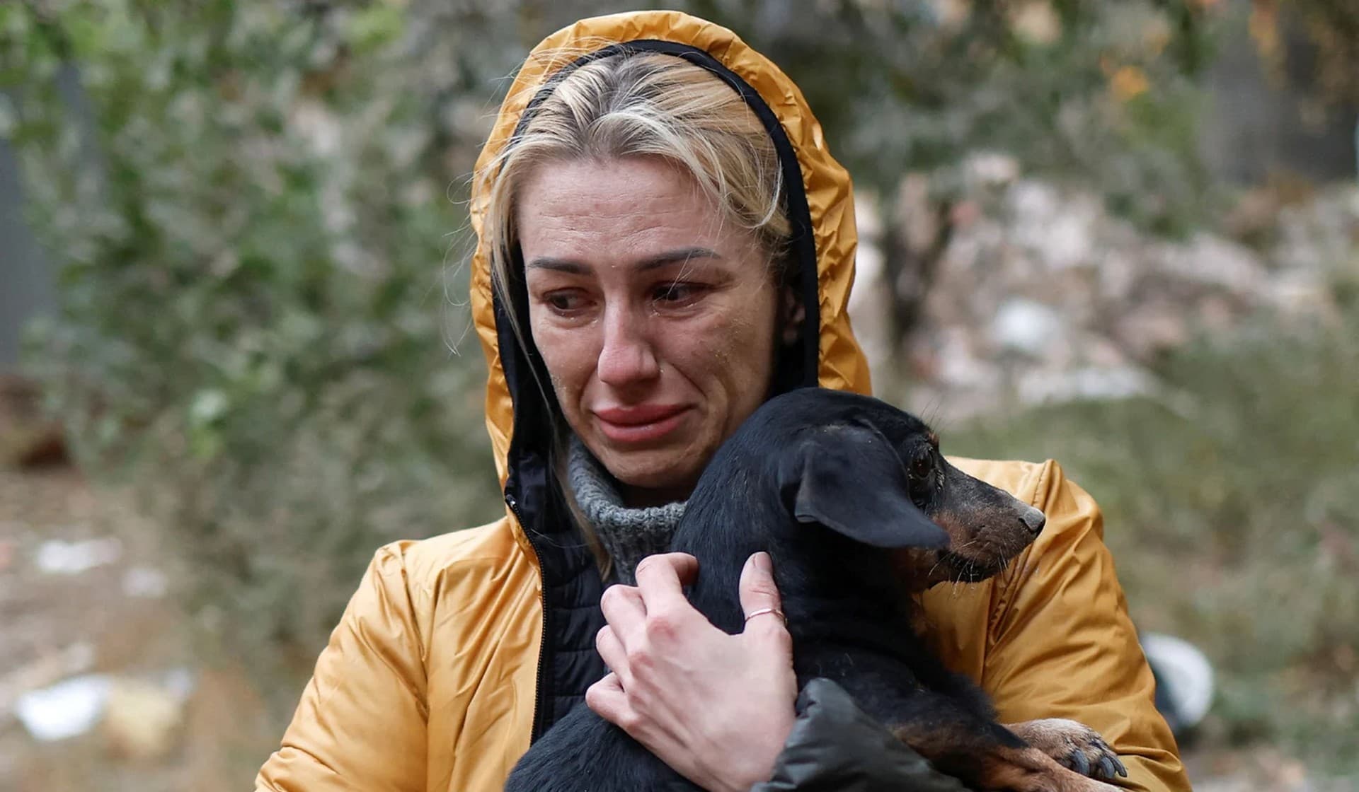 Local resident Kseniia, who survived a Russian missile attack, cries as she holds her dog released by rescuers from the debris of a residential building in Mykolaiv