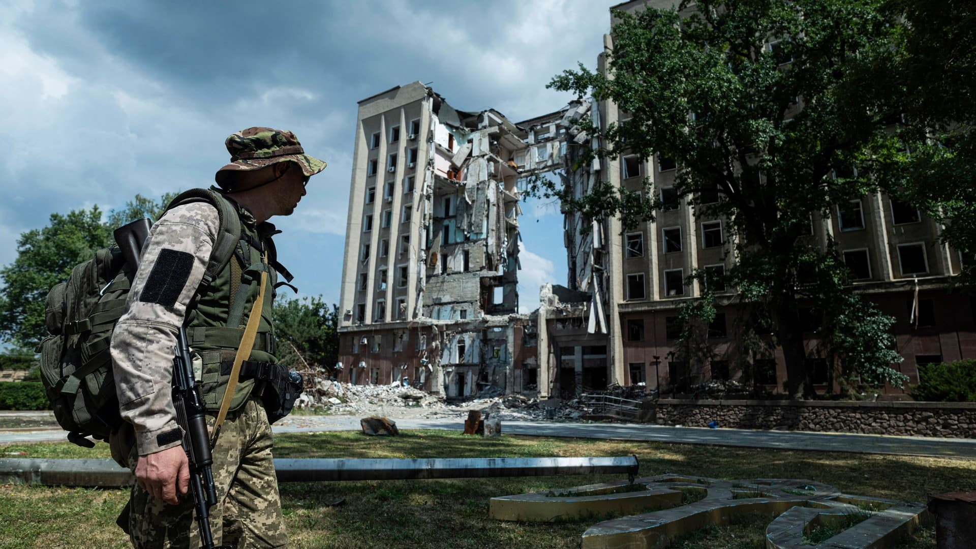 A Ukrainian serviceman stands in front of headquarters of the Mykolaiv Regional Military Administration building destroyed by a Russian attack in Mykolaiv
