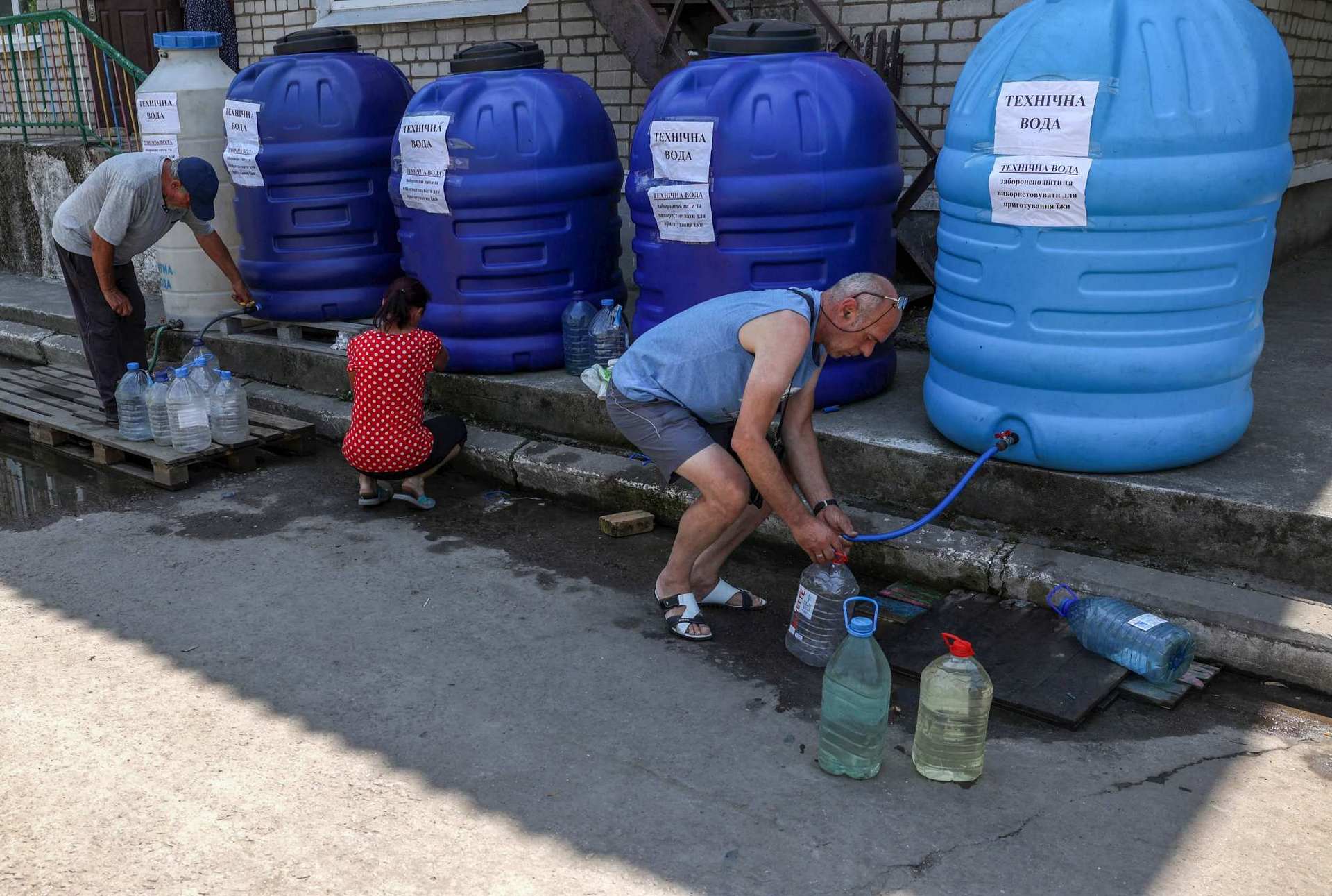 Local residents fill their bottles with non-potable water at a water distribution centre in Nikopol