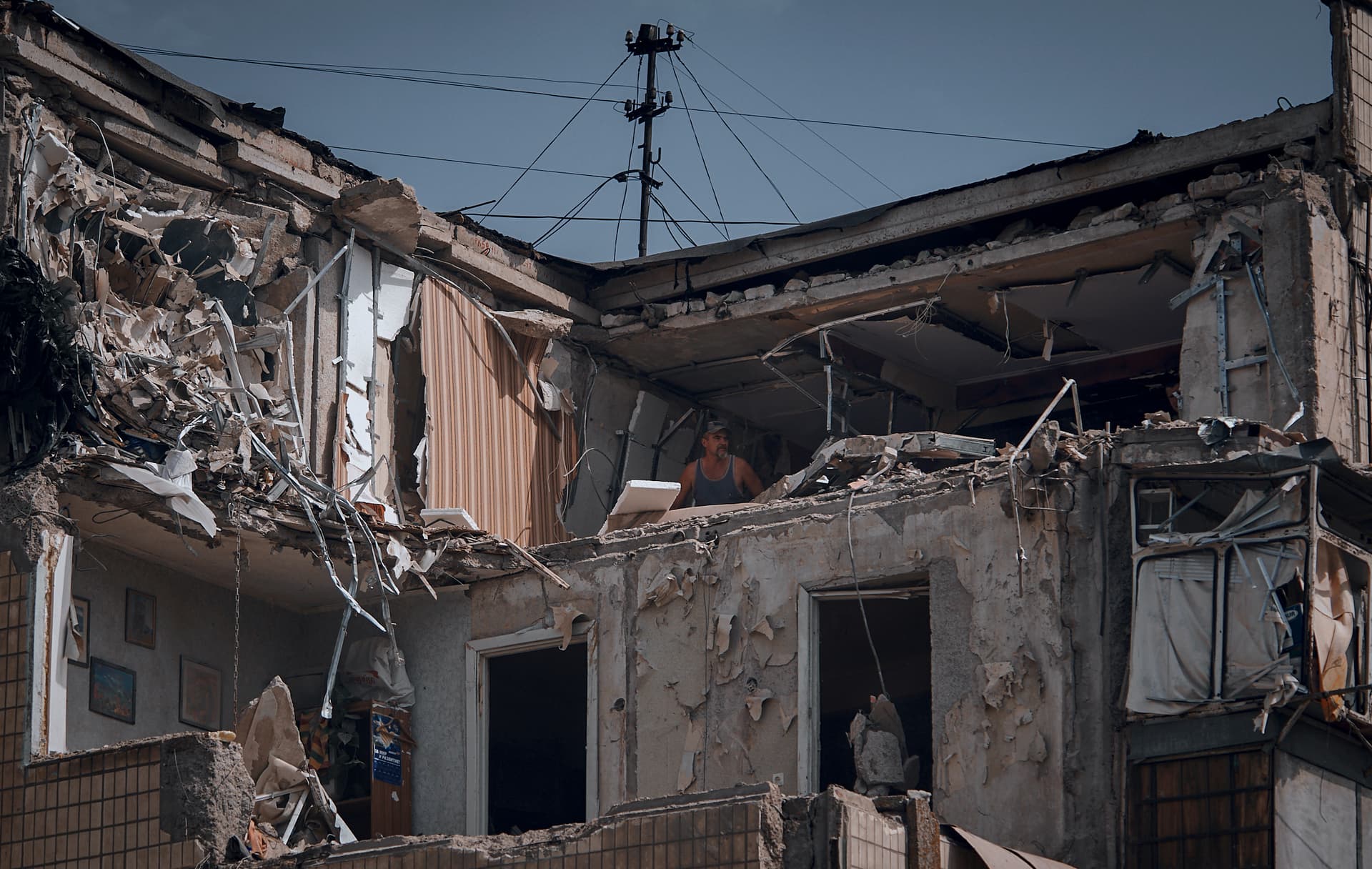 A man cleans an apartment destroyed after Russian shelling in Nikopol