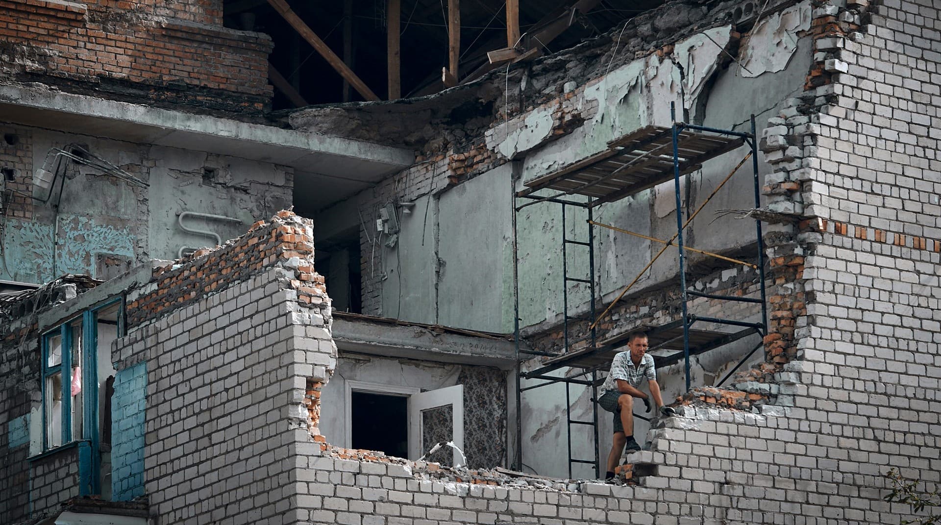 A man looks out from an apartment destroyed after Russian shelling in Nikopol