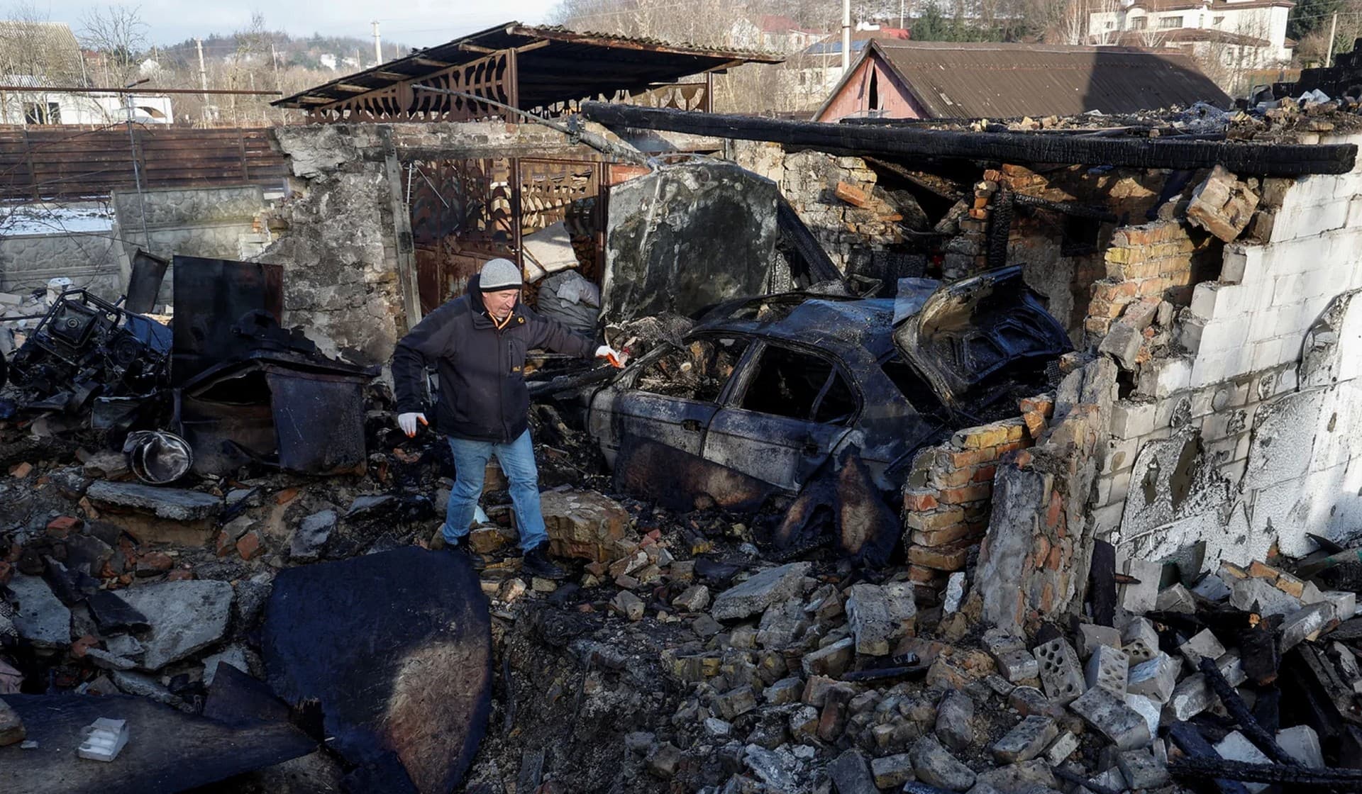 Local resident inspects the remains of his garage, destroyed during a Russian drone strike, in the village of Stari Bezradychi