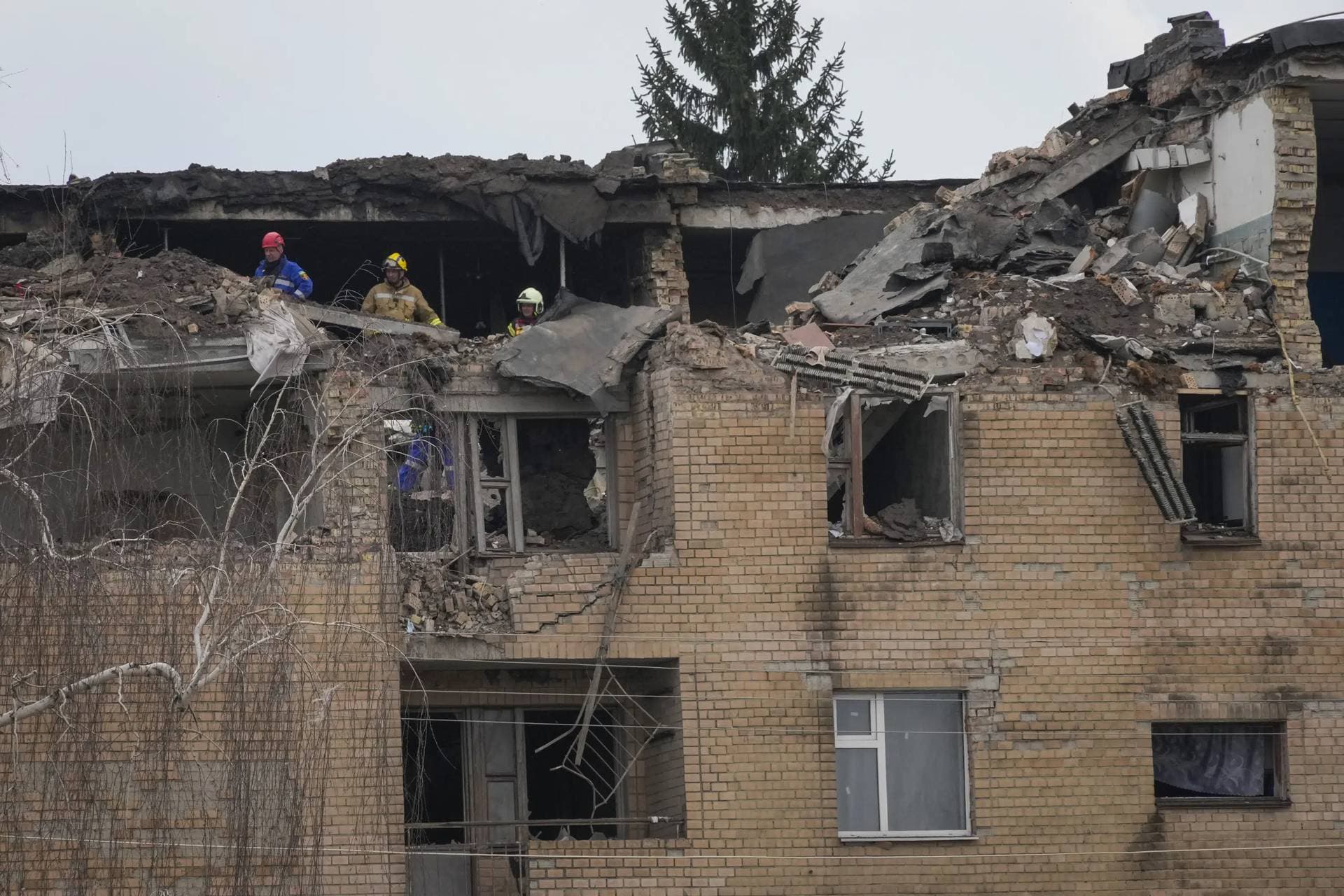 Emergency personnel work at the scene following a drone attack in the town of Rzhyshchiv