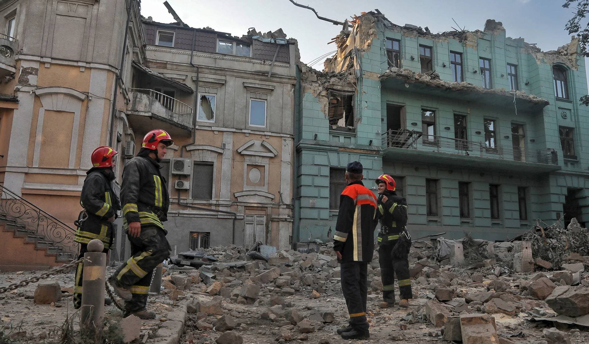 Rescuers stand in front of residential buildings damaged during Russian missile strikes in Odesa