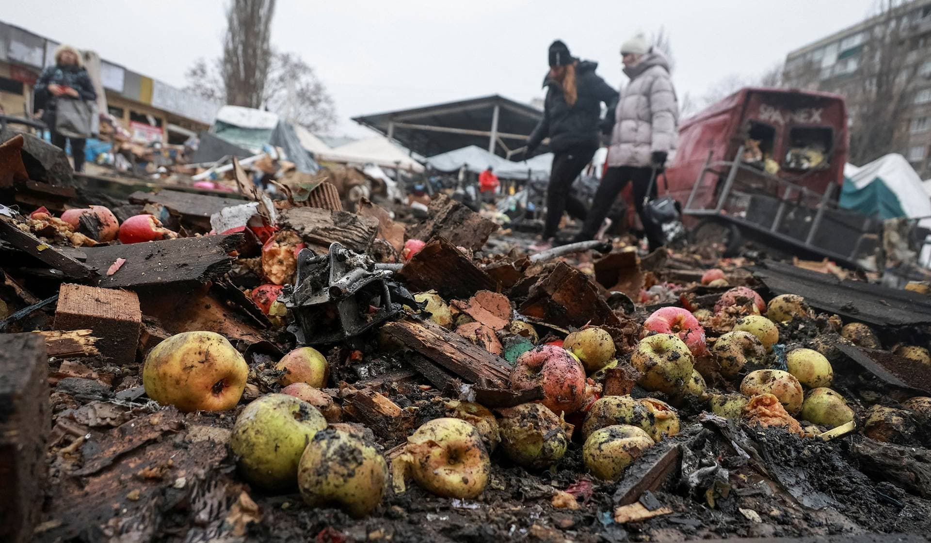Damaged produce lies scattered as residents walk at a street market hit by a Russian drone strike in Odesa