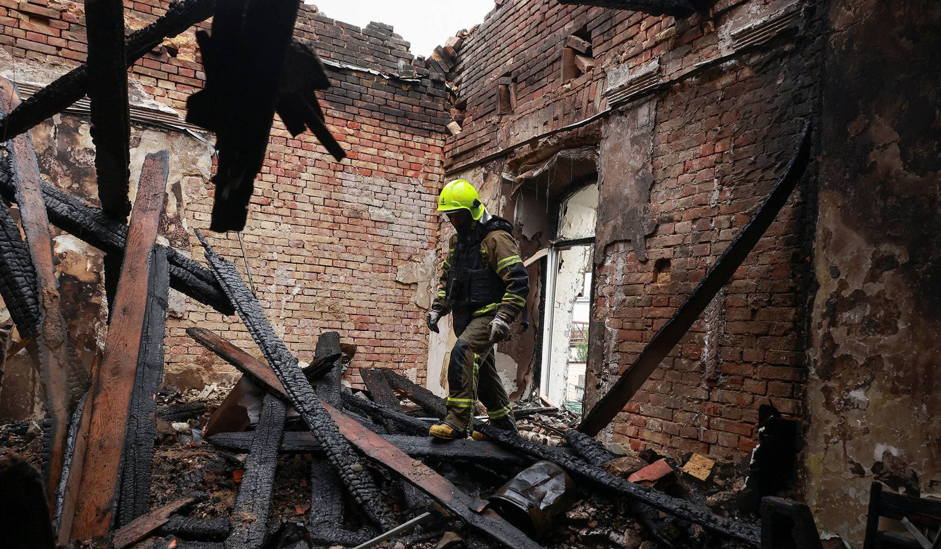A firefighter works at the site of a building damaged during overnight Russian drone strikes in Odesa