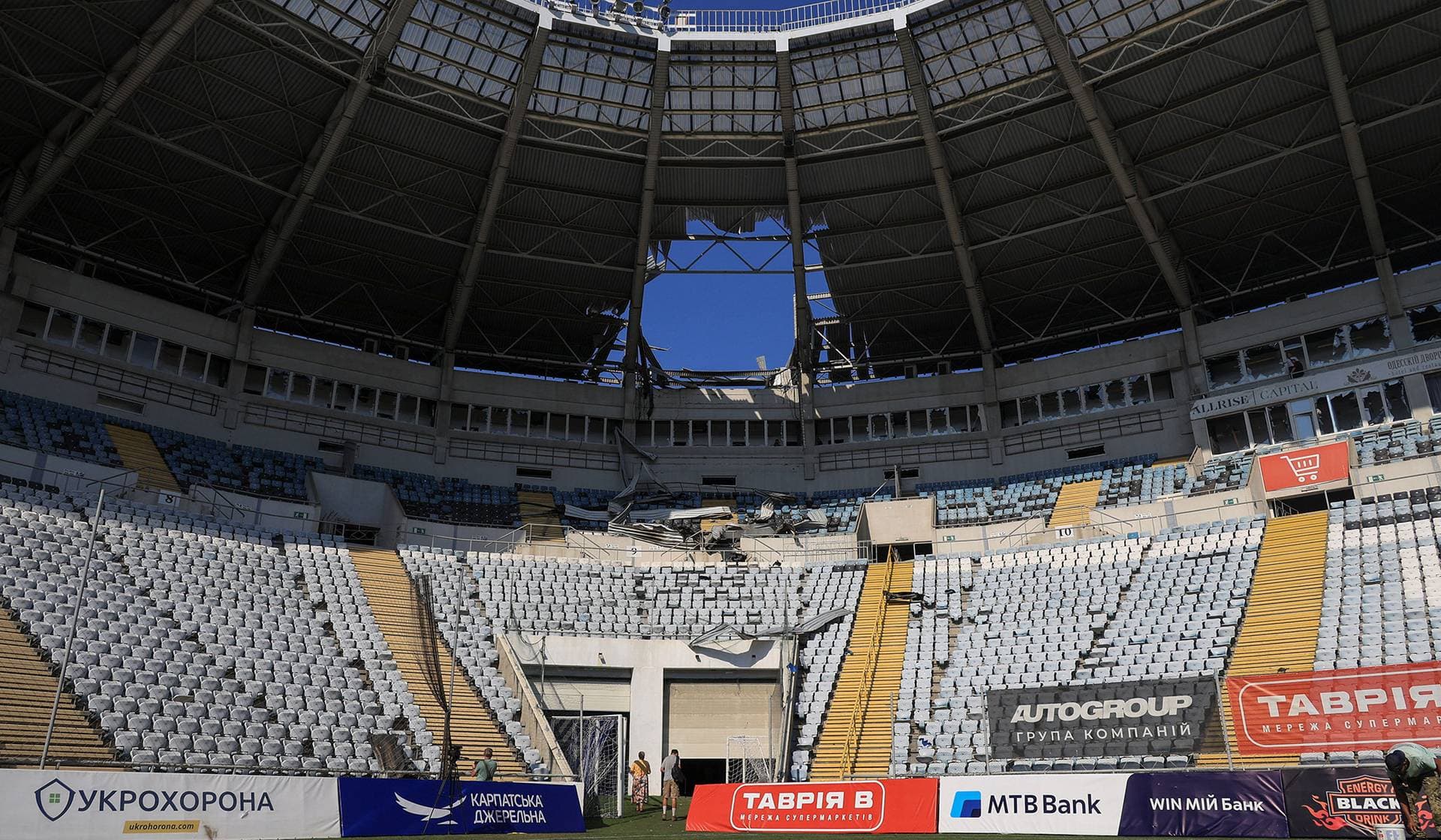 Men look at damage to the Chornomorets Stadium, which was hit by a Russian drone strike in Odesa