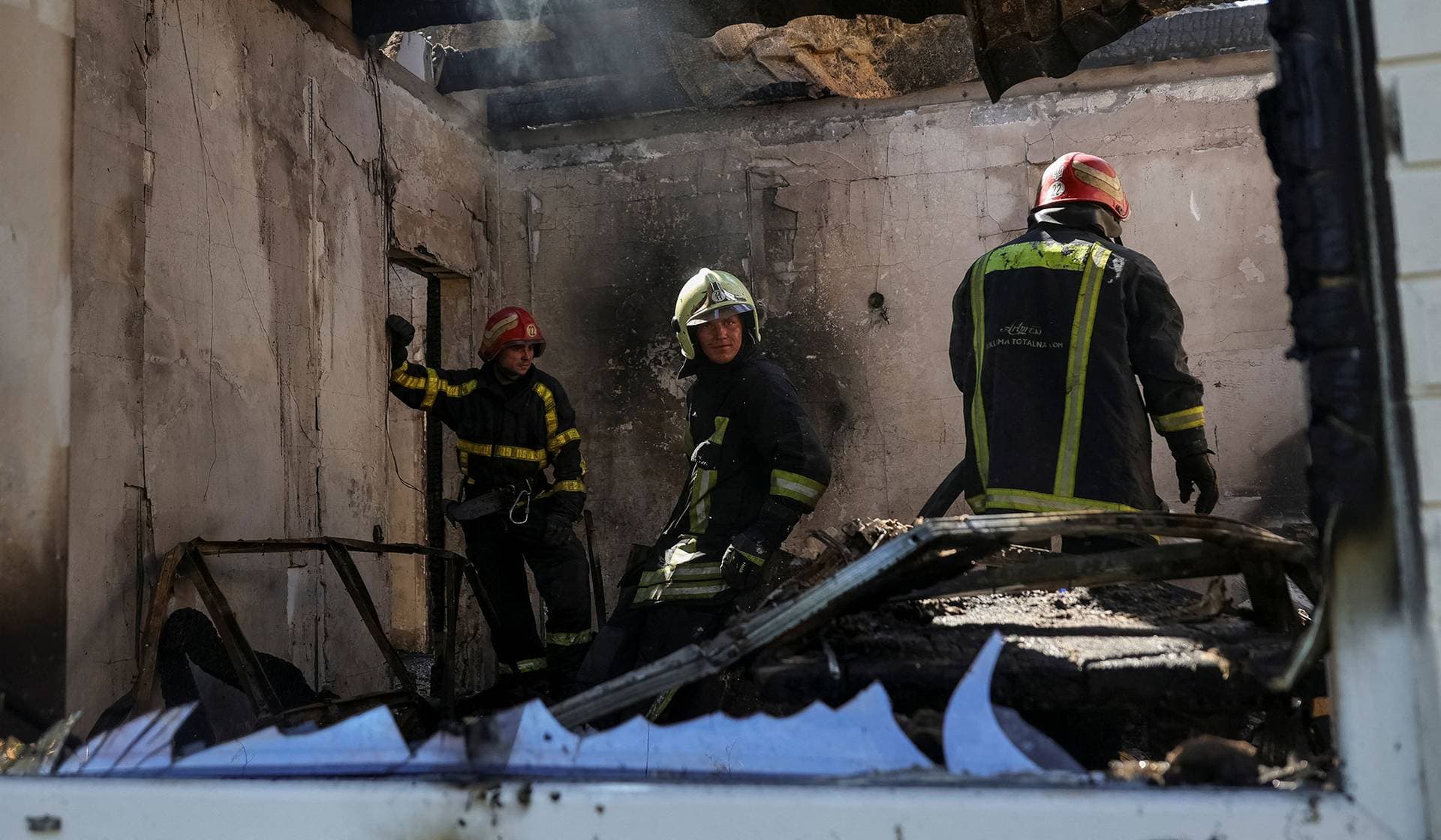 Rescuers work at the site of the private house hit by a Russian drone strike near Chornomorsk
