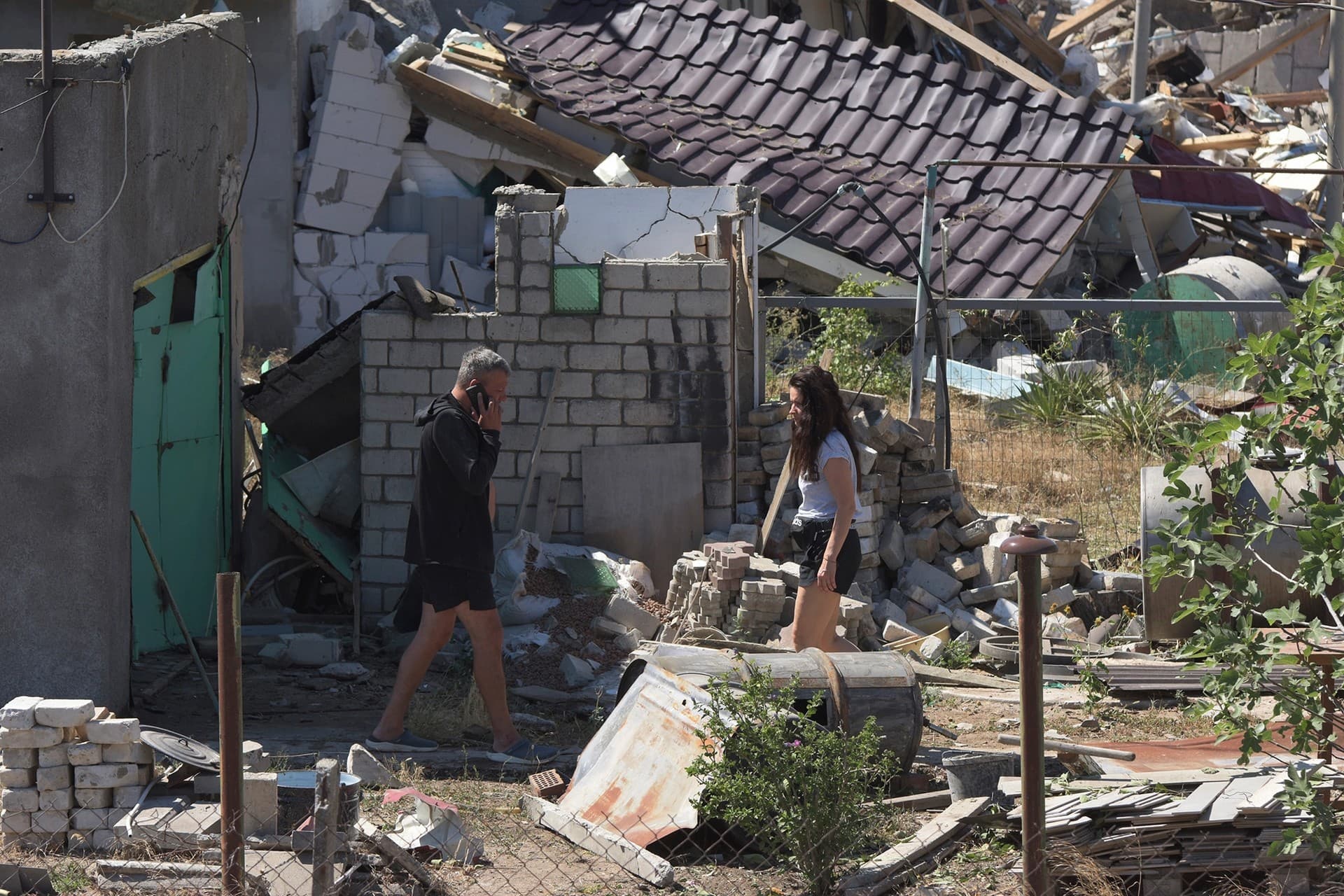 People walk in a yard of a apartment building destroyed by Russian shelling on the outskirts of Odesa