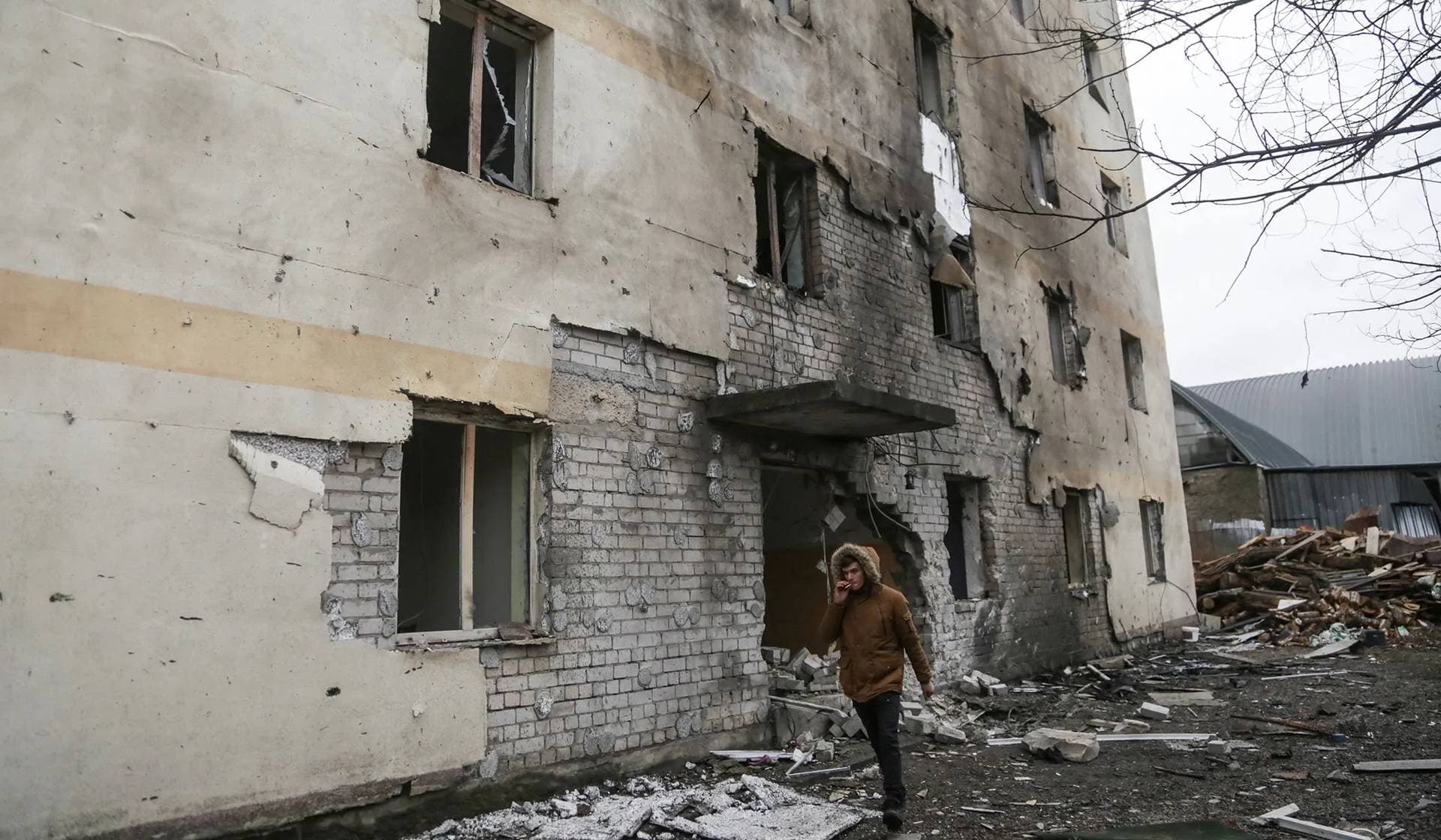 A man walks next to a residential building damaged by a Russian drone strike in Odesa