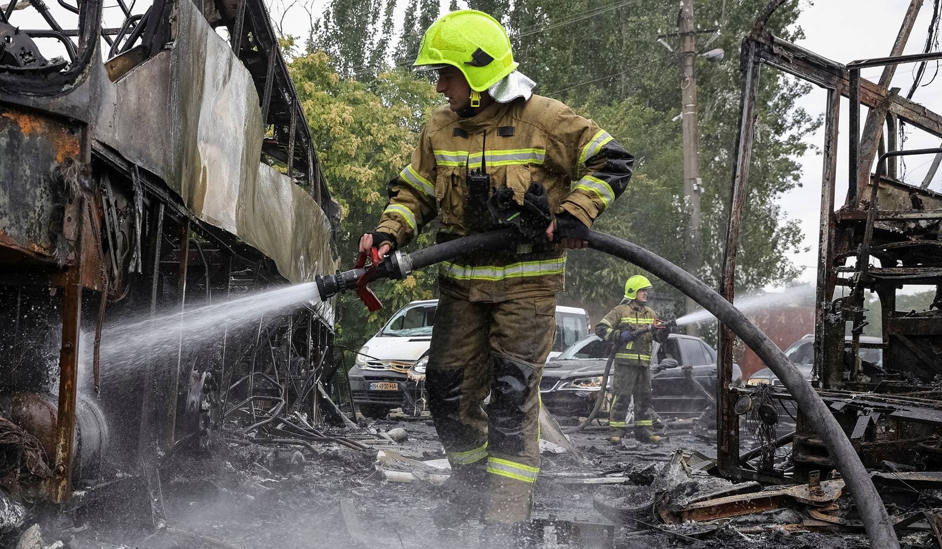 Firefighters work at the site of a bus parking hit by a Russian drone strike in Odesa